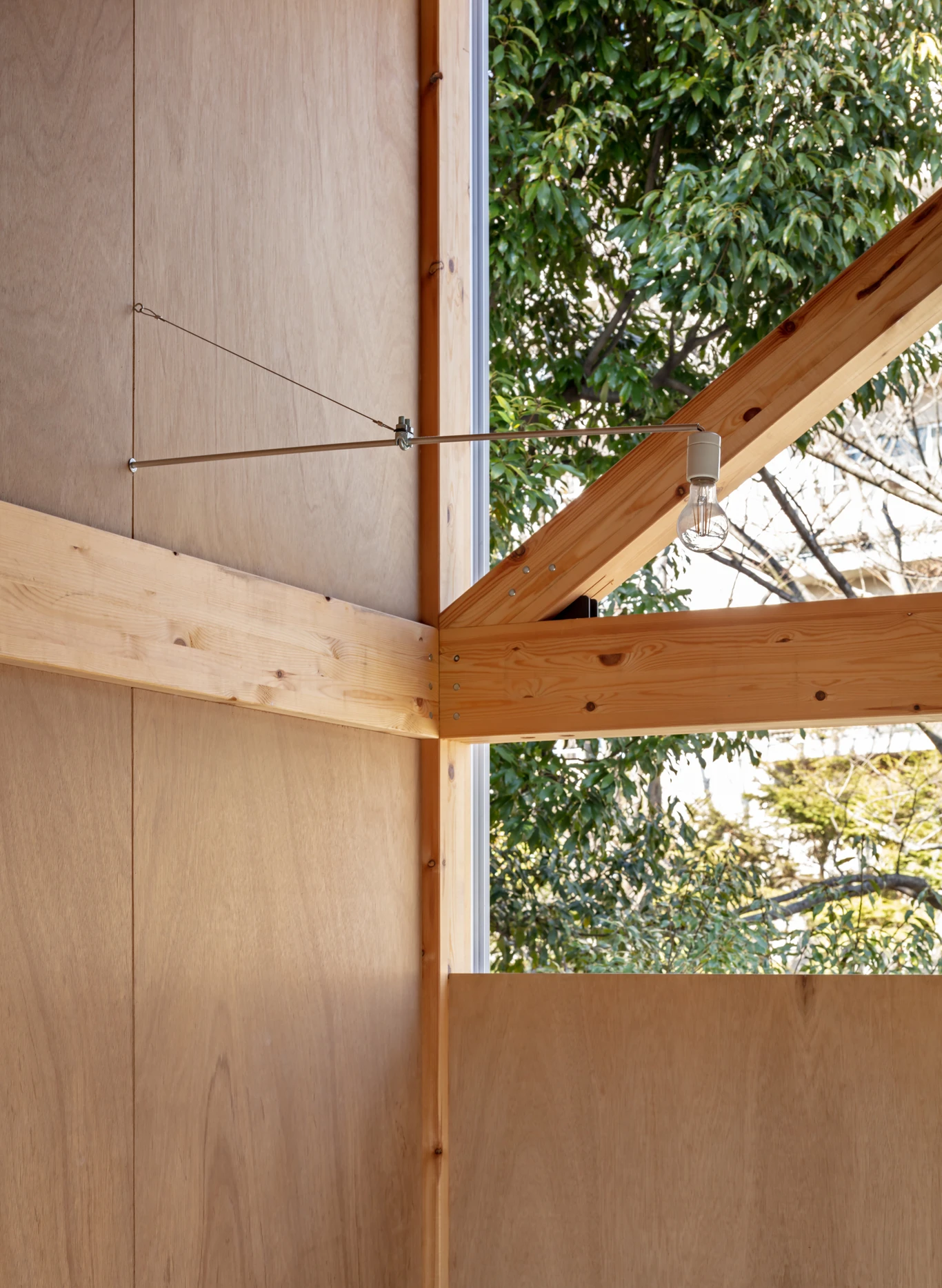House S/Shop B (ba hütte) by KimuraMatsumoto Architects — Interior detail of House S/Shop B reveals the refined joinery where timber beams meet corrugated metal cladding.