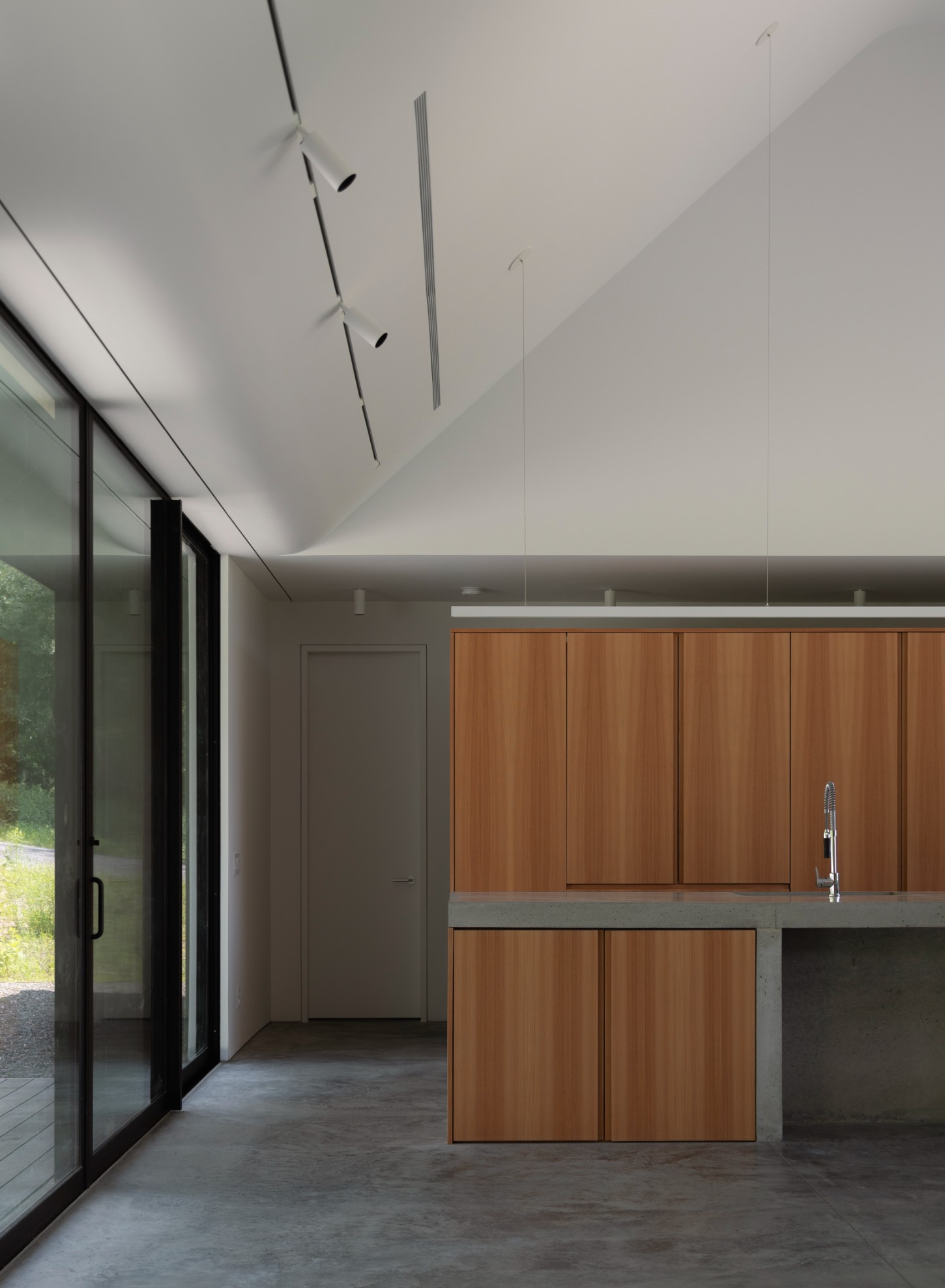 House in a Meadow by Group Projects Architecture — Interior view of the kitchen and dining area within House in a Meadow, showcasing the materiality strategy that defines the project.
