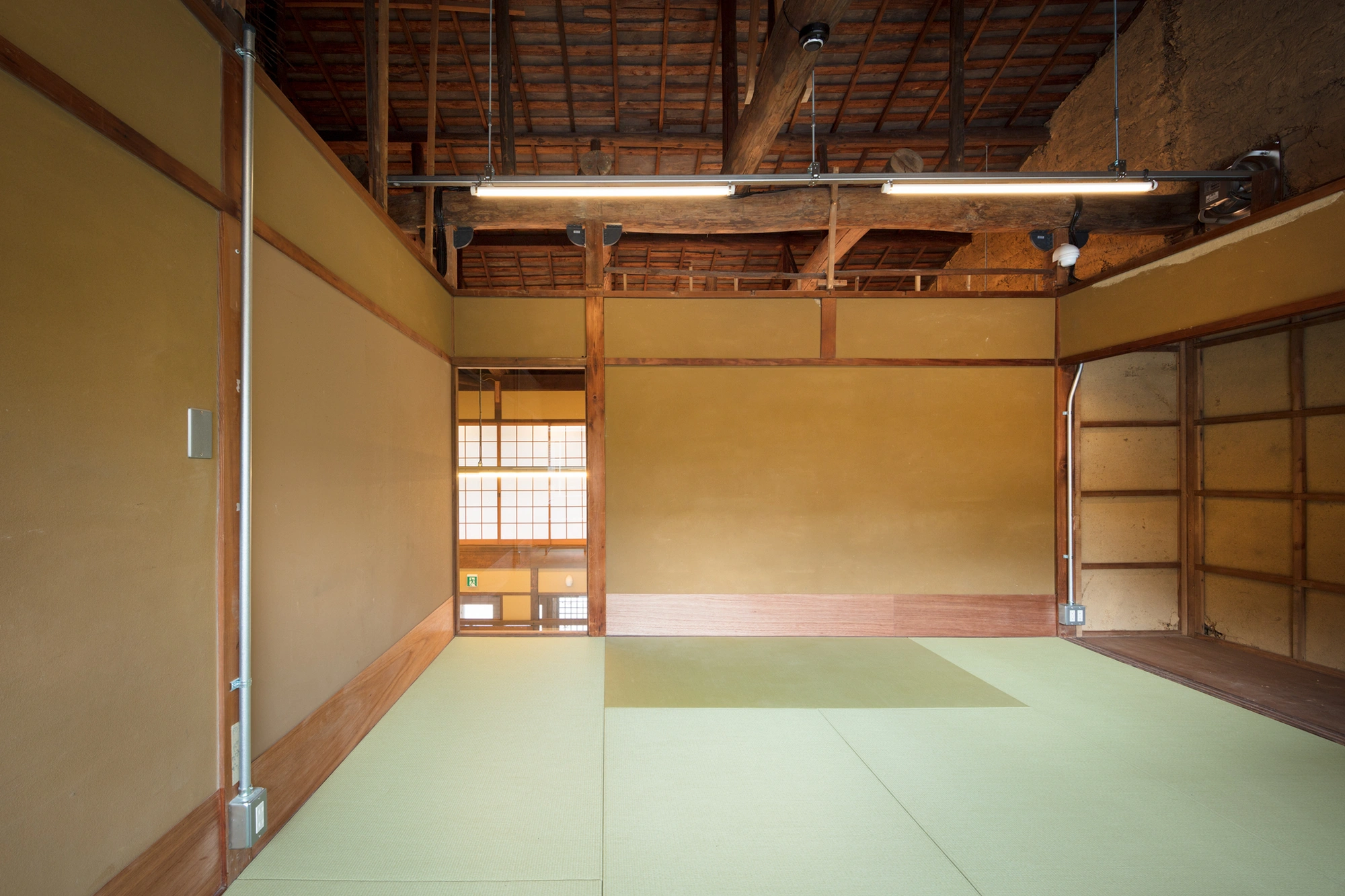 Blue Bottle Coffee Kyoto Cafe by Schemata Architects — The interior volume of Blue Bottle Coffee Kyoto extends the exterior threshold across a continuous pale terrazzo floor marked by subtle geometric divisions.