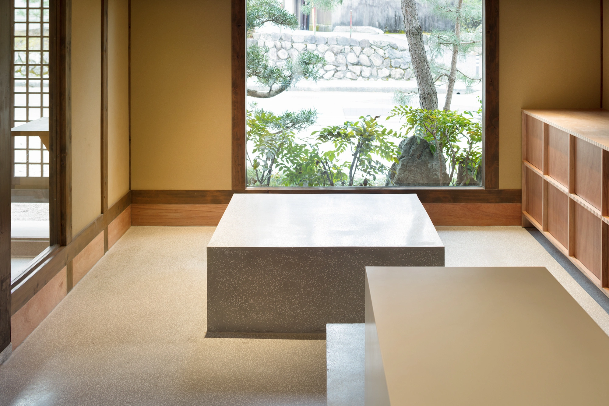 Blue Bottle Coffee Kyoto Cafe by Schemata Architects — Two sunken bathtubs occupy the foreground of this thermal bathing space, their minimalist forms carved into a continuous terrazzo floor that extends...