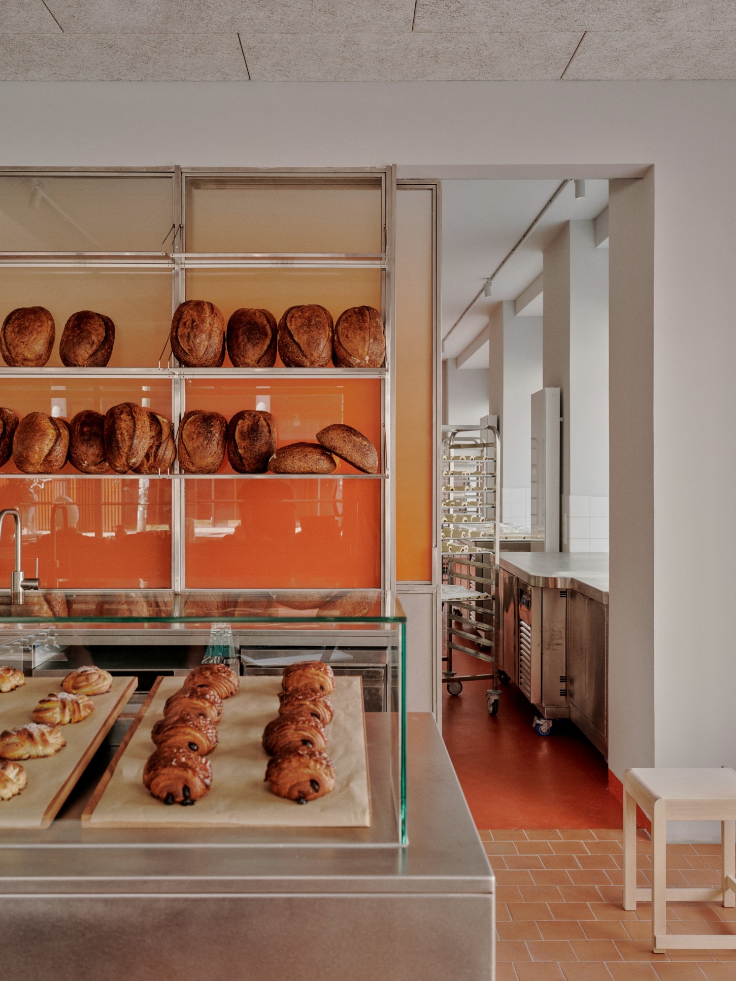 ACID Cafe by Plantea Studio by Plantea Estudio — A patisserie display window frames artisanal breads and pastries with architectural precision.