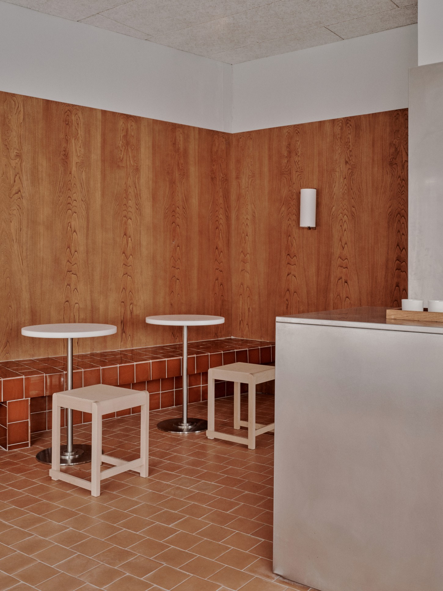 ACID Cafe by Plantea Studio by Plantea Estudio — A corner detail of ACID Cafe reveals the studied material hierarchy that defines the space.