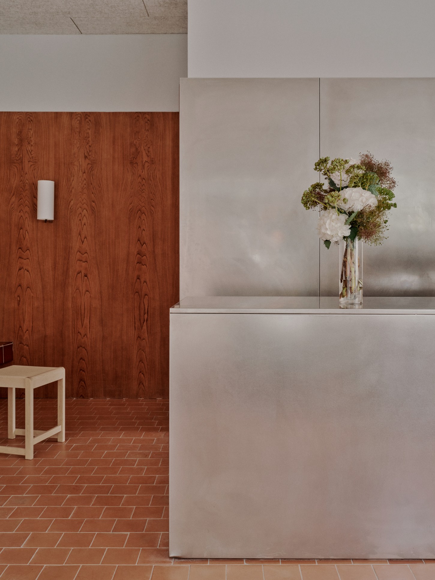 ACID Cafe by Plantea Studio by Plantea Estudio — A sectional view of ACID Cafe reveals the material contrast at its core: warm terracotta brick laid in herringbone pattern grounds the left space, where a...