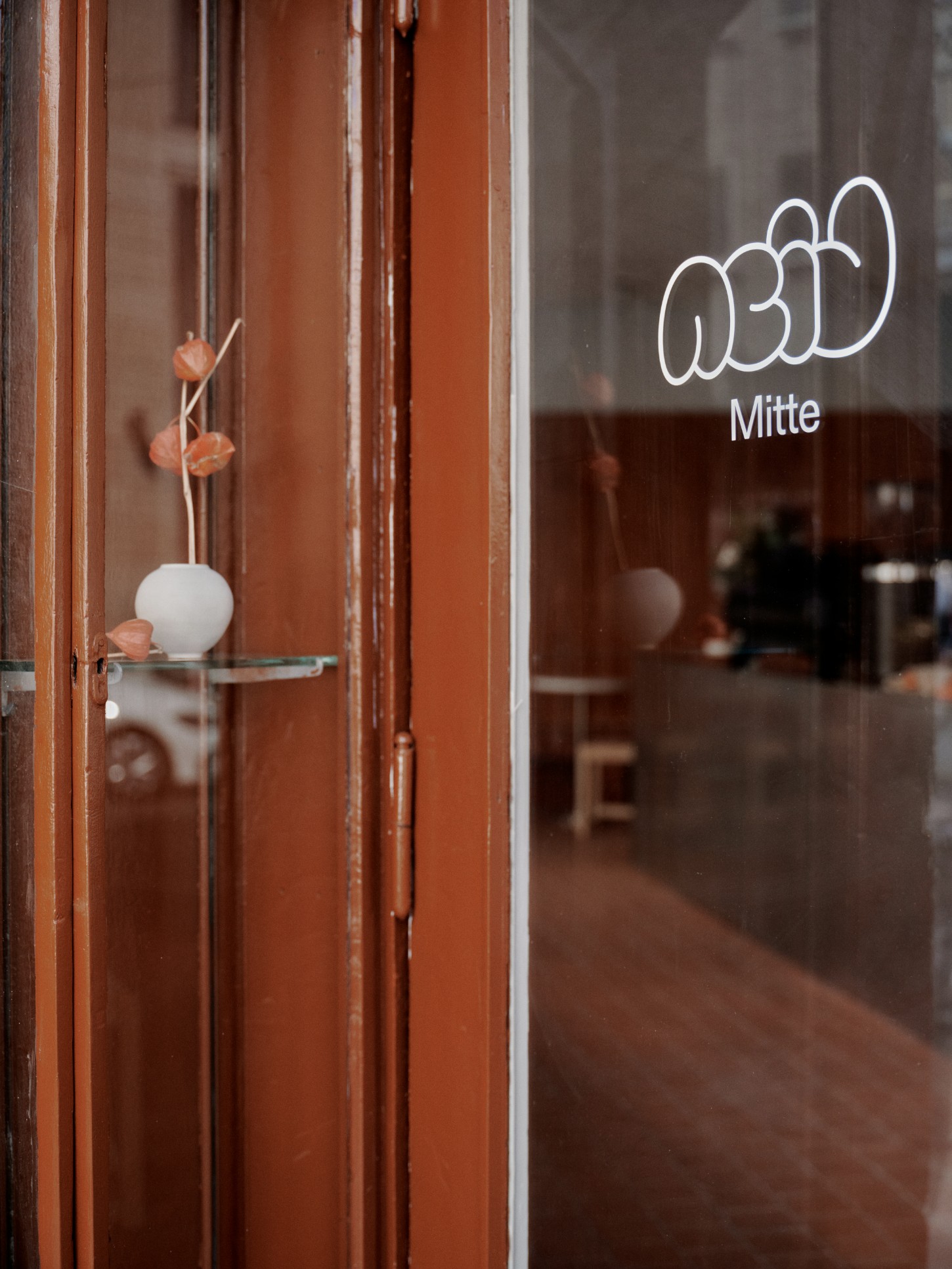 ACID Cafe by Plantea Studio by Plantea Estudio — The storefront entrance of Acid Mitte café frames a carefully composed threshold detail.