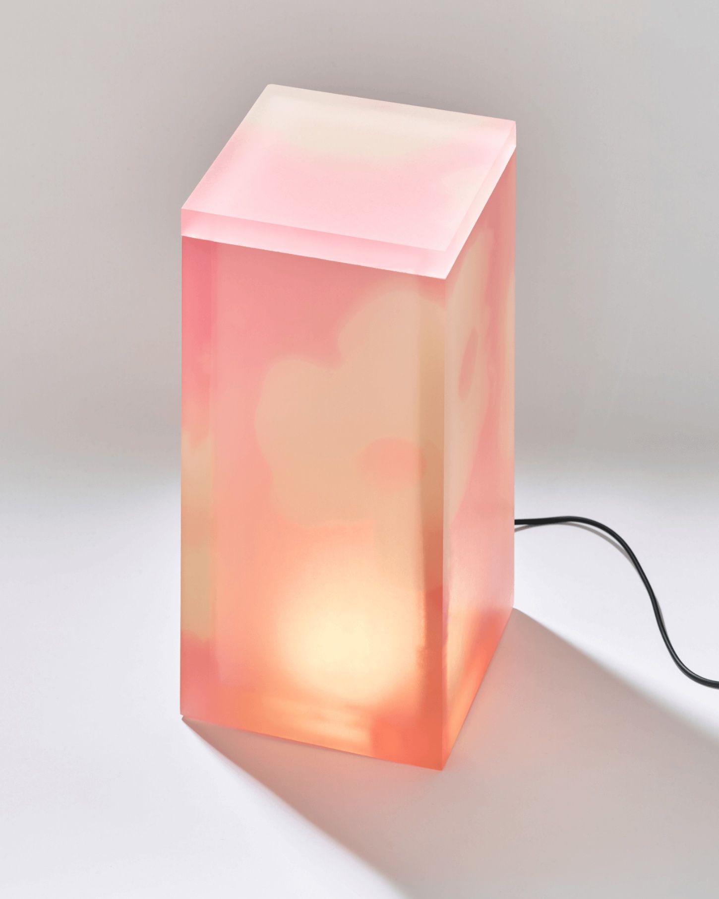 Selected Works by Forever Studio — A translucent resin or acrylic block lamp in gradient pink-to-cream coloration, glowing from an internal light source.