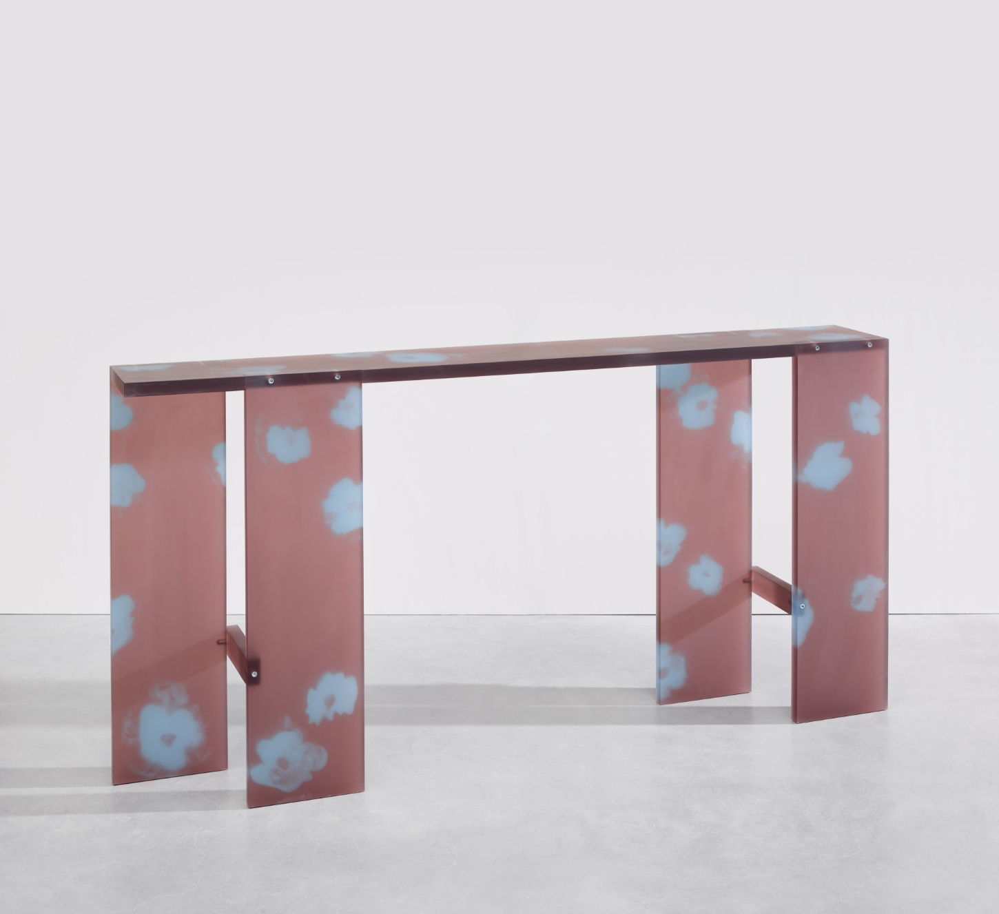 Selected Works by Forever Studio — A console table with a dark timber top spans horizontally across four vertical panels clad in mauve-pink fabric printed with pale blue circular motifs.