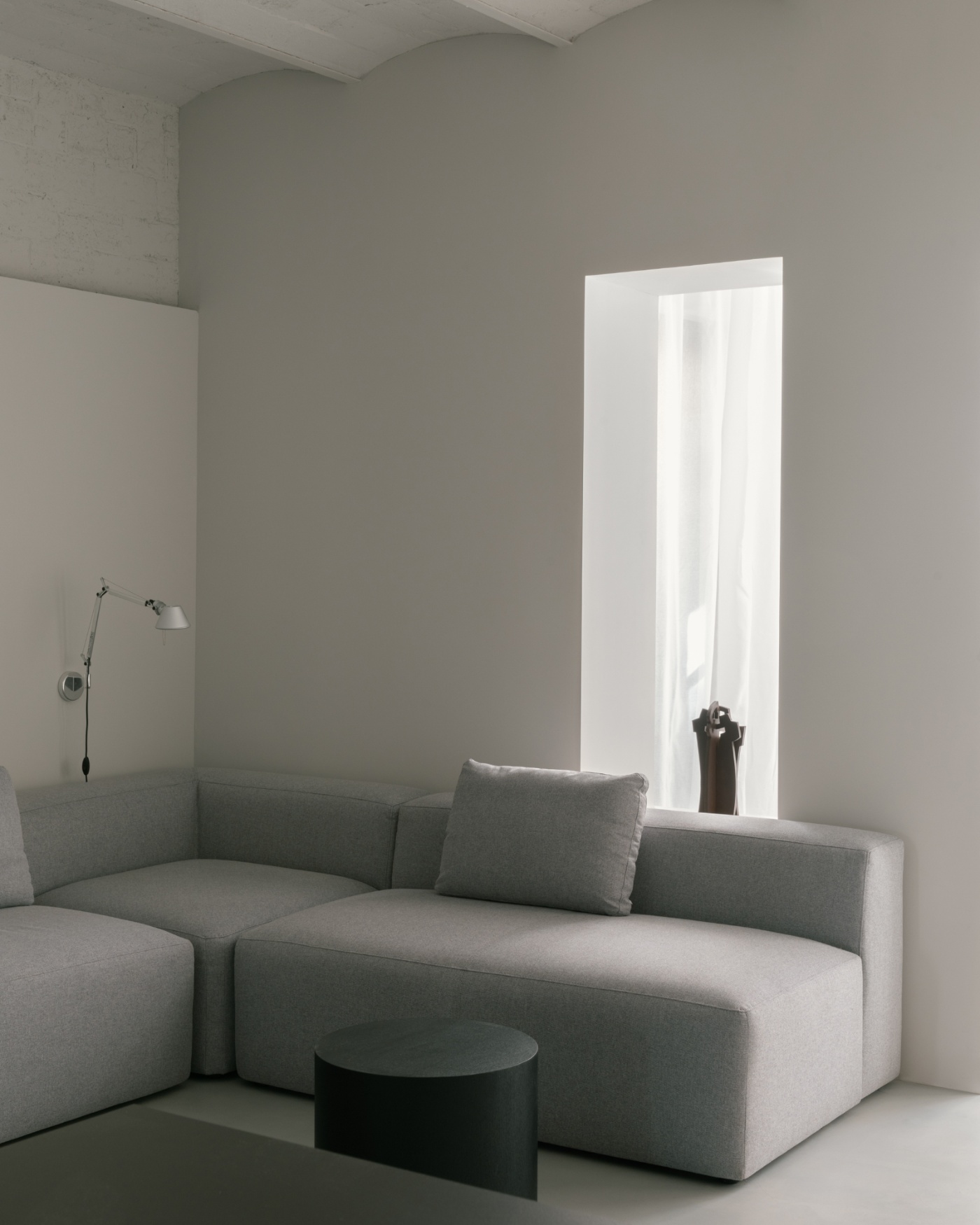 Casa Norte by CORREA Studio — A modular sectional sofa in light grey linen anchors the open living space, its rounded volumetric forms contrasting sharply with the room's rectilinear...