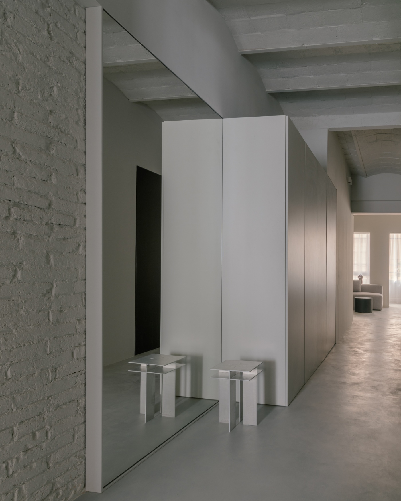 Casa Norte by CORREA Studio — A corridor threshold framing a mirrored alcove that doubles the perceived depth of the space.