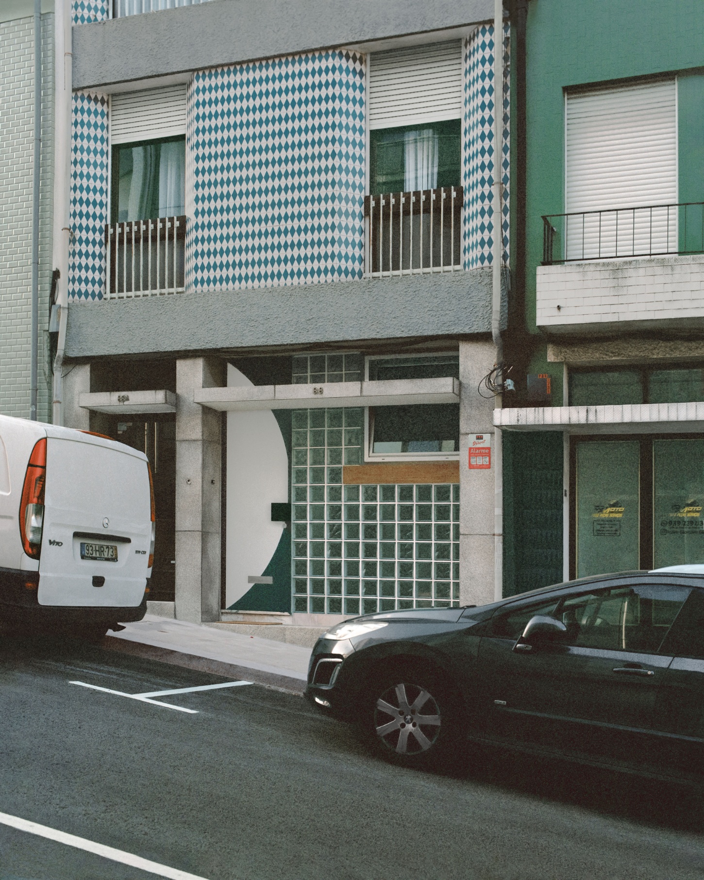 'Fireworks in White' by Willem Pab — A street-level photograph of a mixed-use building facade in Porto captures the intersection of residential and commercial zones.
