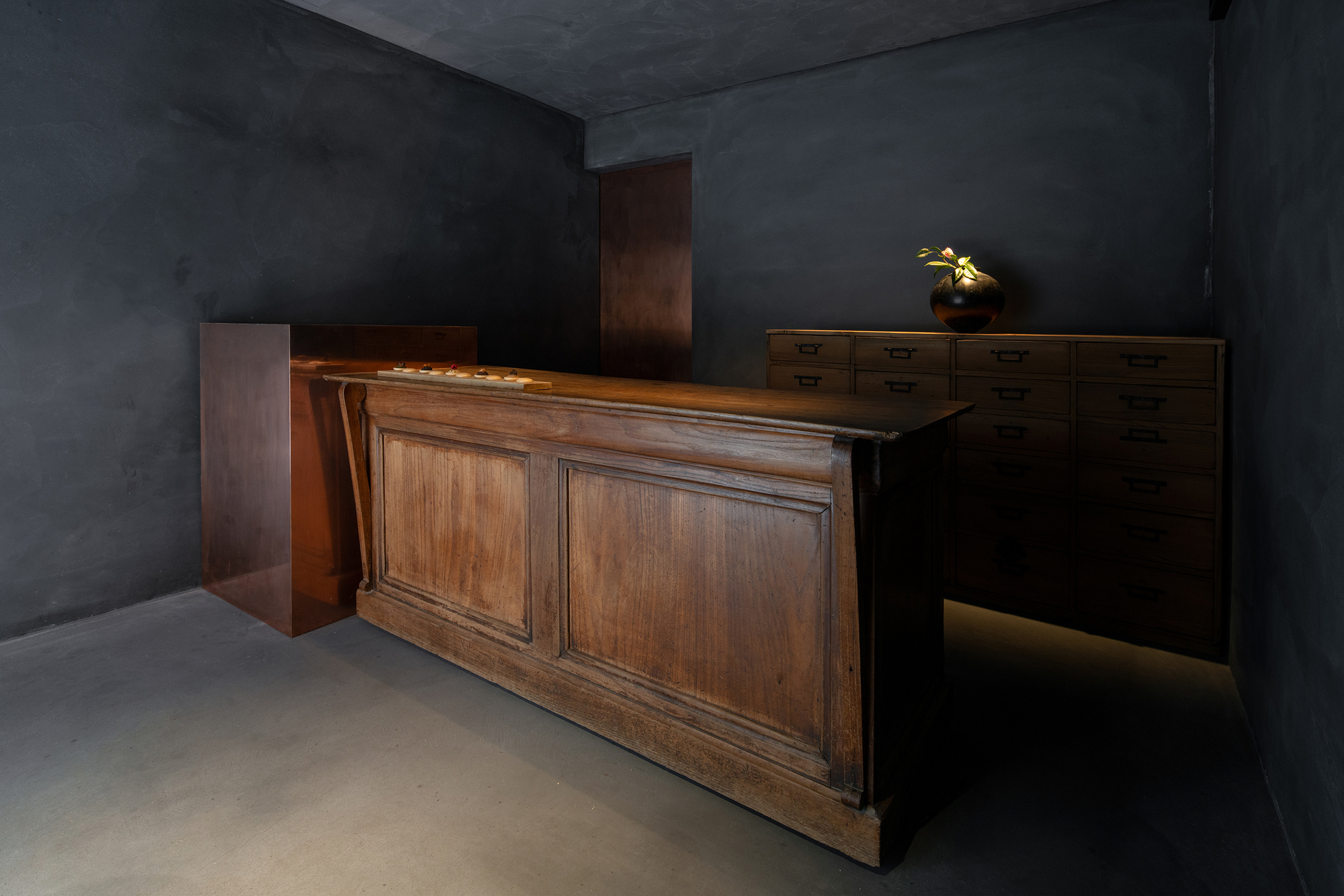 mitomi by Koyori + Aterier Salt — A timber counter dominates the foreground, its two-panel cabinet doors rendered in warm oak with visible grain patterns.