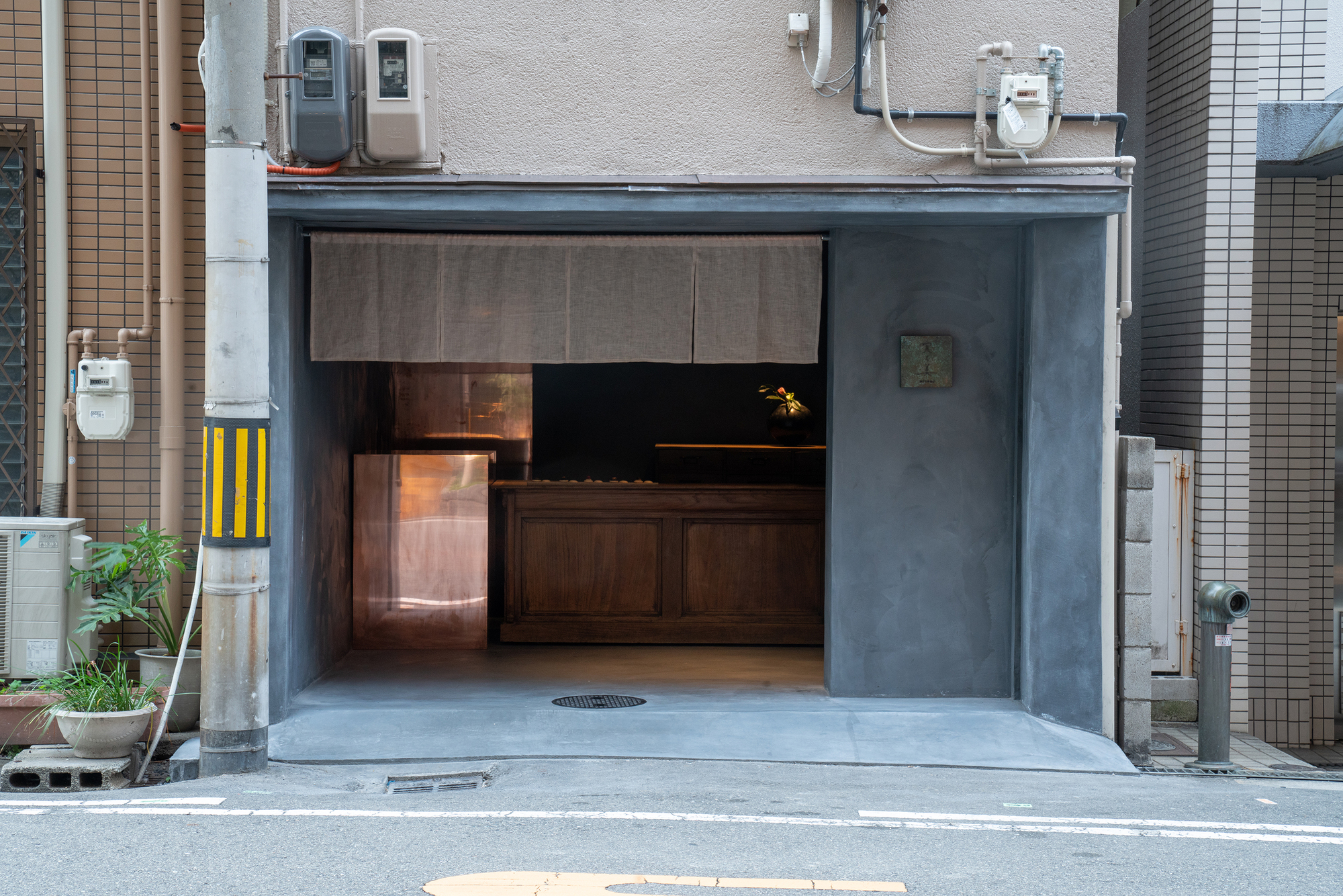 mitomi by Koyori + Aterier Salt — The storefront entrance is rendered in charcoal render with a recessed threshold framing the interior.