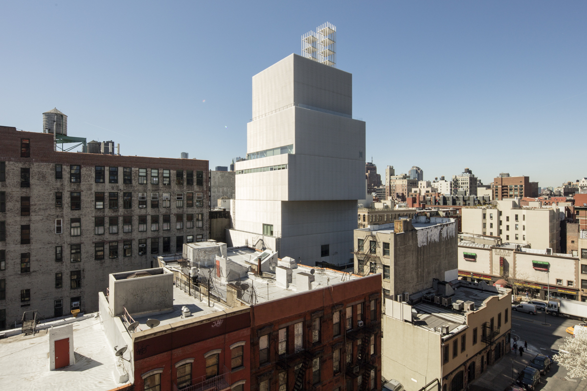 New Art Museum by SANAA — SANAA's stacked rectangular volumes appear to float above the Lower East Side streetscape, their white rendered facade creating stark contrast against...