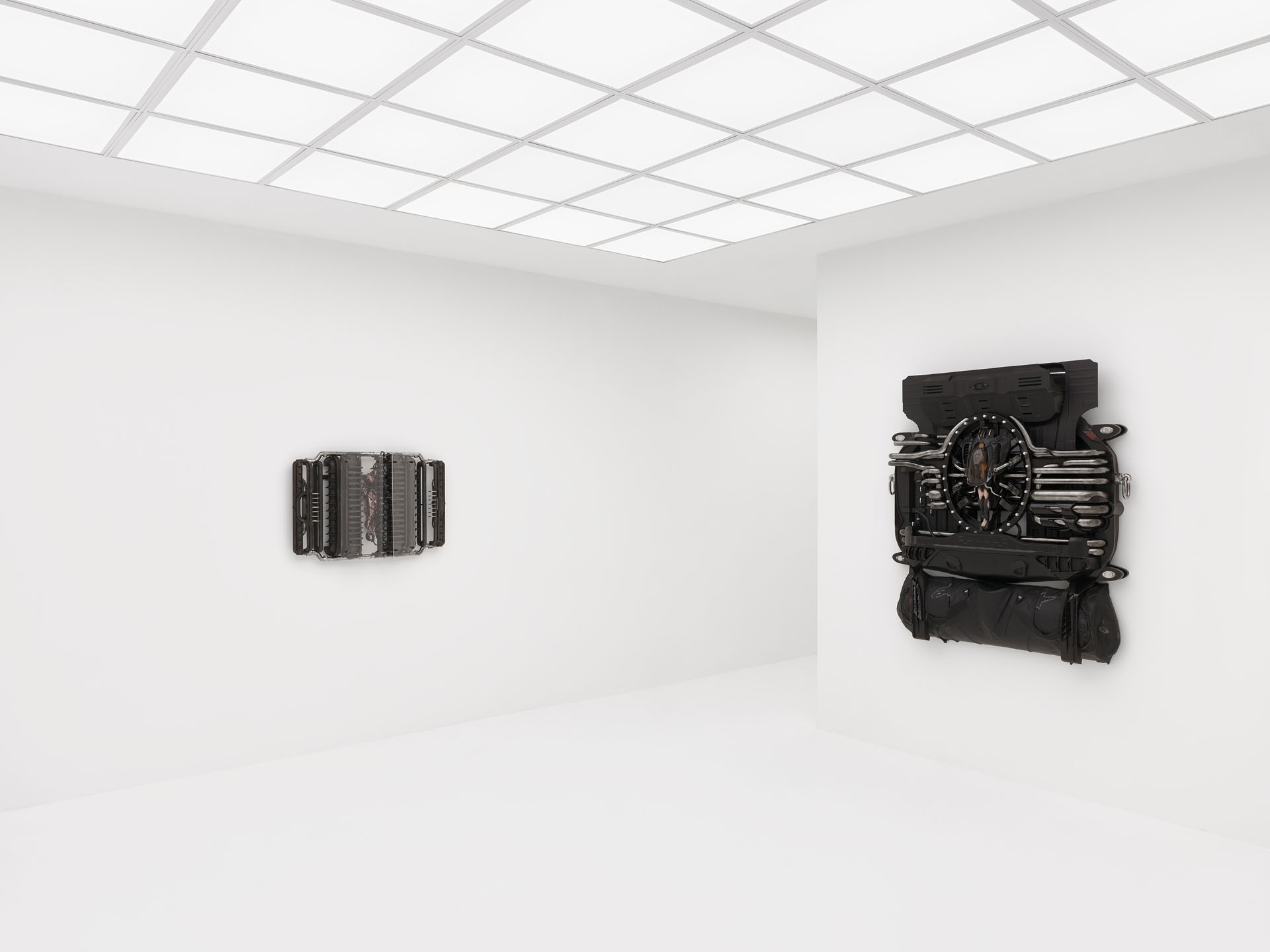 ENDO– by Taylor Ashby Hawkins at ASHES/ASHES — Two wall-mounted sculptural assemblies present disassembled automotive engine components—ribbed aluminum cylinder heads and finned cooling...