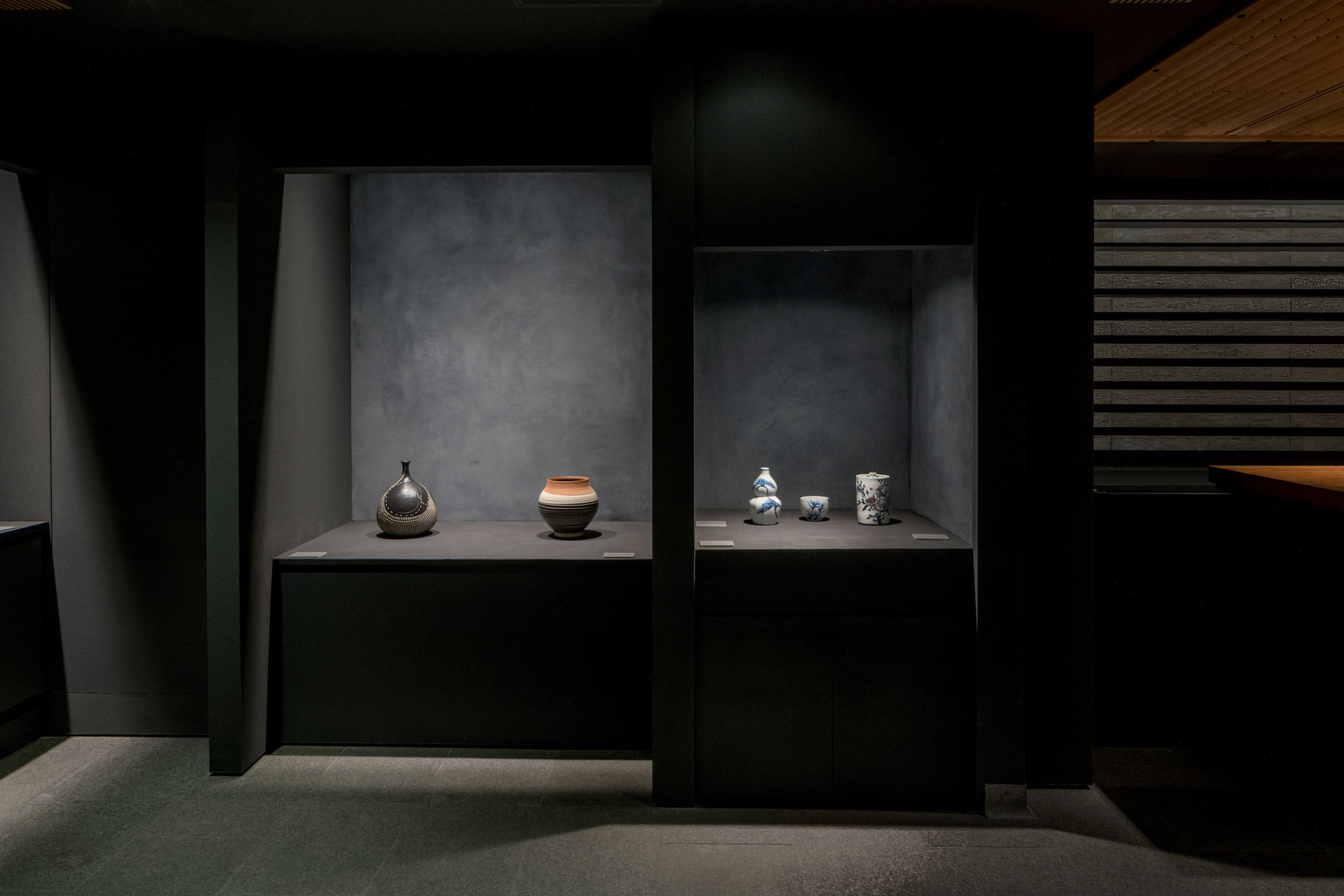 Kondo Museum in Kyoto by Mamiya Shinichi Design Studio — Display cases with recessed gallery niches set into dark walls create volumetric depth through shadow.
