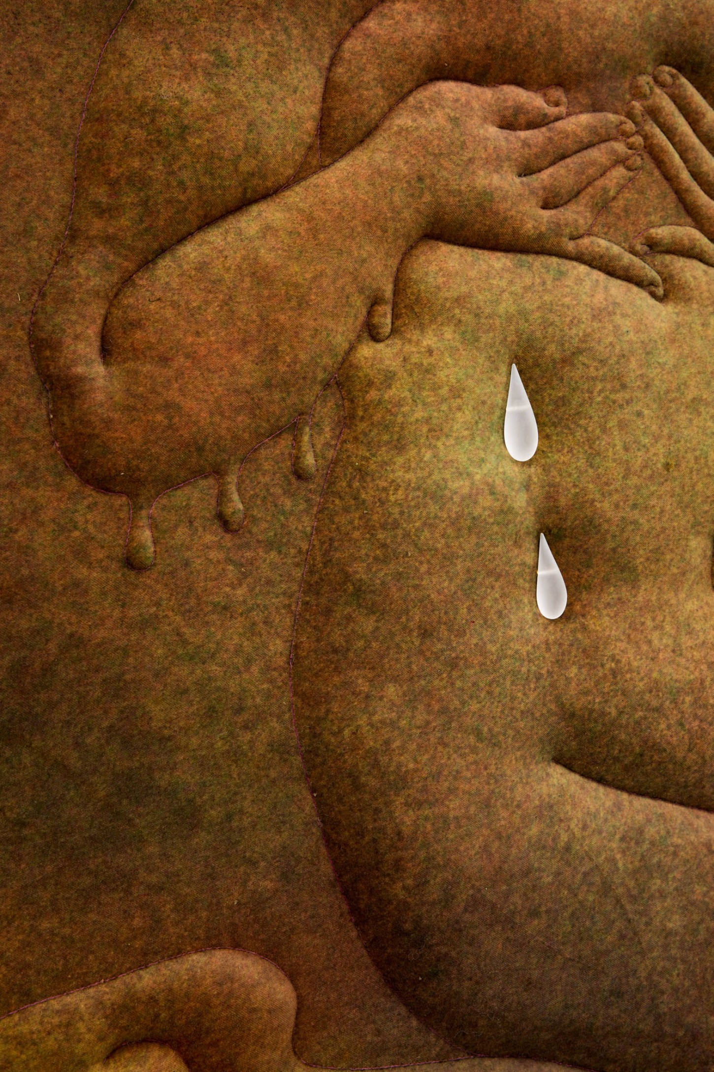 Thirst by Eliška Konečná at Polansky — A close-up relief carving in sandstone depicting overlapping nude figures in repose, their bodies emerging from a weathered stone ground with warm ochre and...