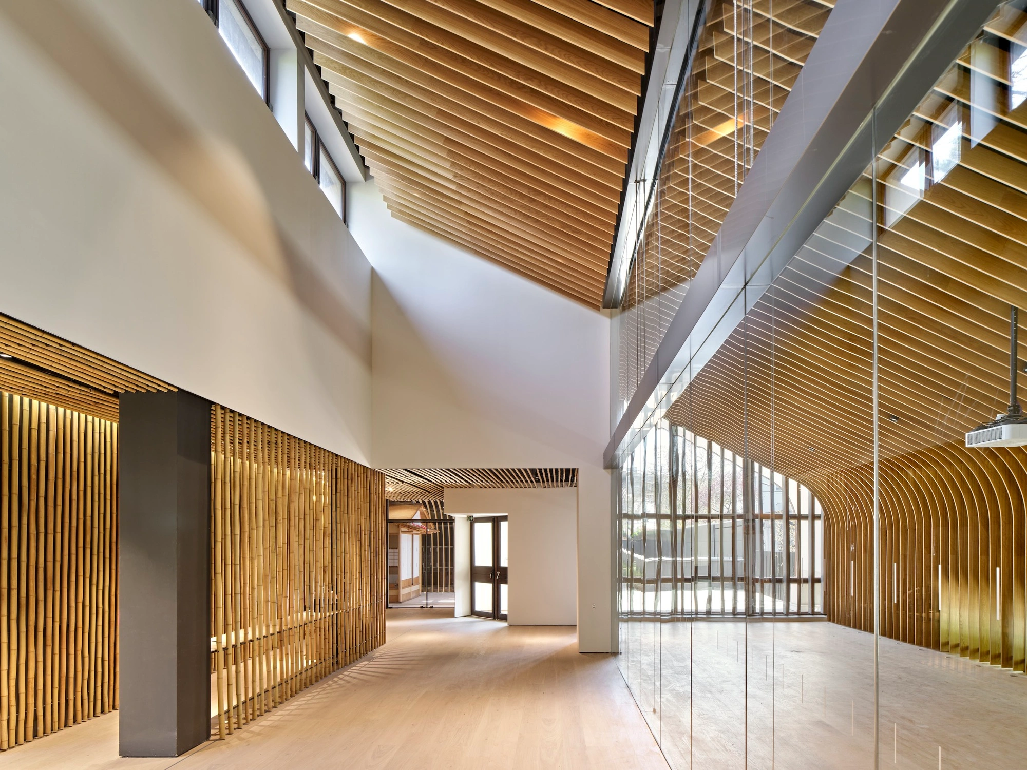 Albert Kahn Museum by Kengo Kuma & Associates — A continuous interior gallery volume defined by rhythmic vertical aluminum striations wrapping curved wooden screening elements.