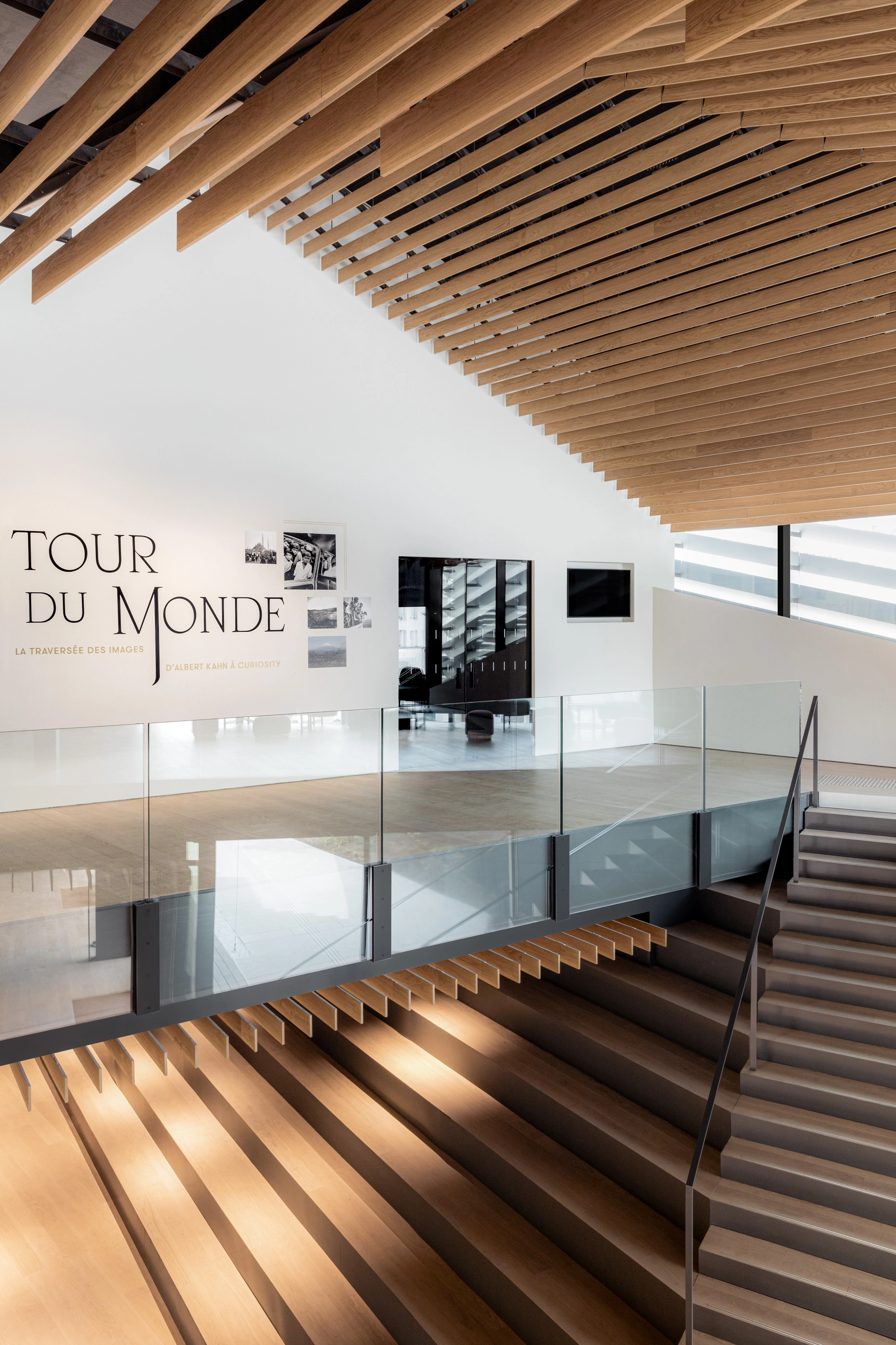 Albert Kahn Museum by Kengo Kuma & Associates — The museum's interior staircase descends through multiple levels, with timber treads casting sharp shadows across the floor plane.