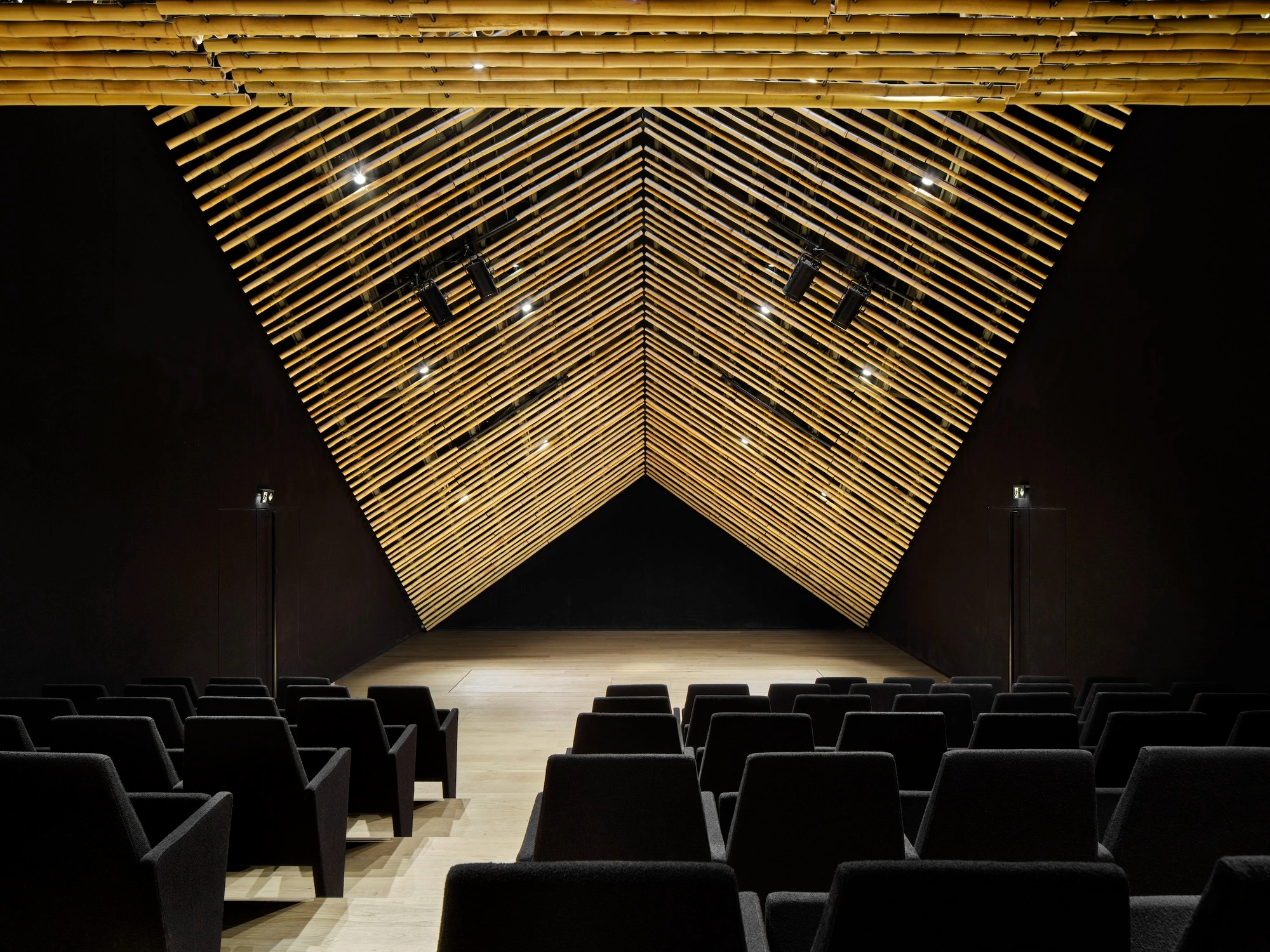Albert Kahn Museum by Kengo Kuma & Associates — The auditorium interior showcases a dramatic inverted V-shaped ceiling composed of continuous horizontal aluminum striations that create strong linear...
