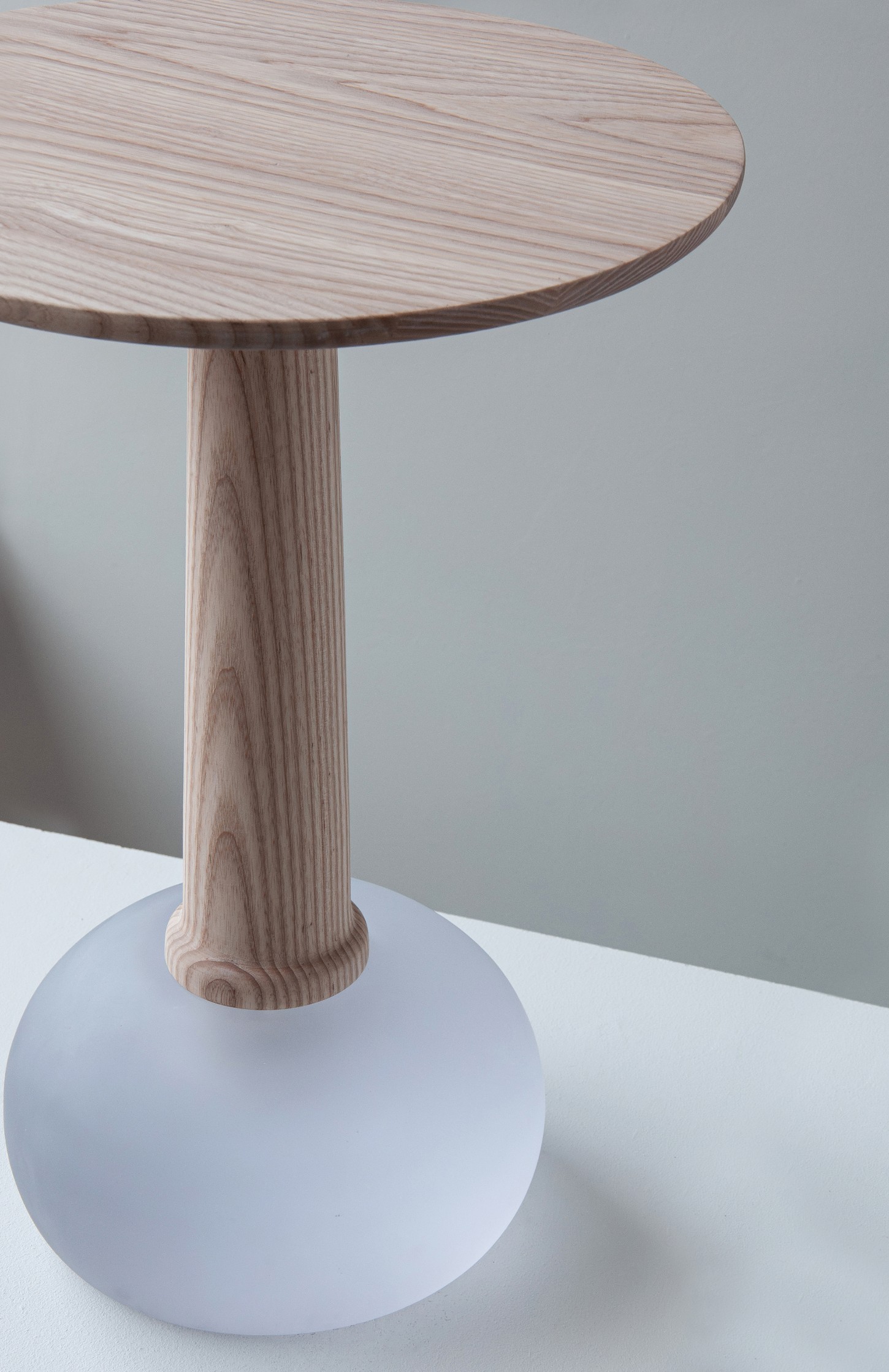 'Burn & Turn' by Adrian Bursell + Siri Svedborg — A pedestal table from 'Burn & Turn' featuring a turned timber column with pronounced vertical fluting that tapers subtly toward its base.