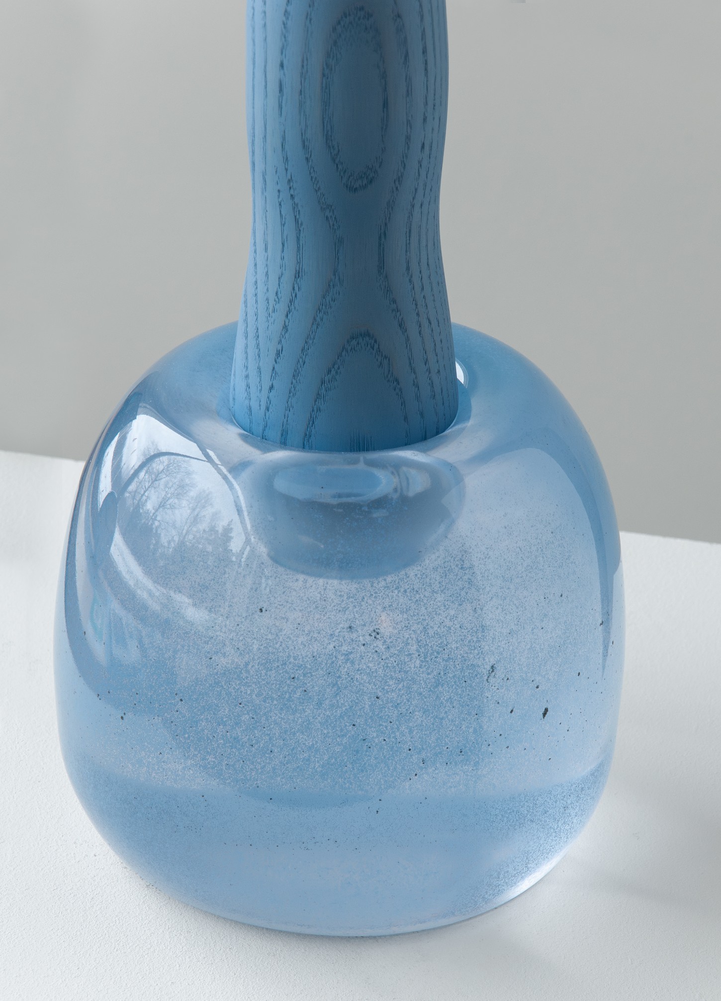 'Burn & Turn' by Adrian Bursell + Siri Svedborg — A hand-cast glass vessel in pale periwinkle sits as the bulbous base of this hybrid object, its surface marked by irregular frosting and visible casting...