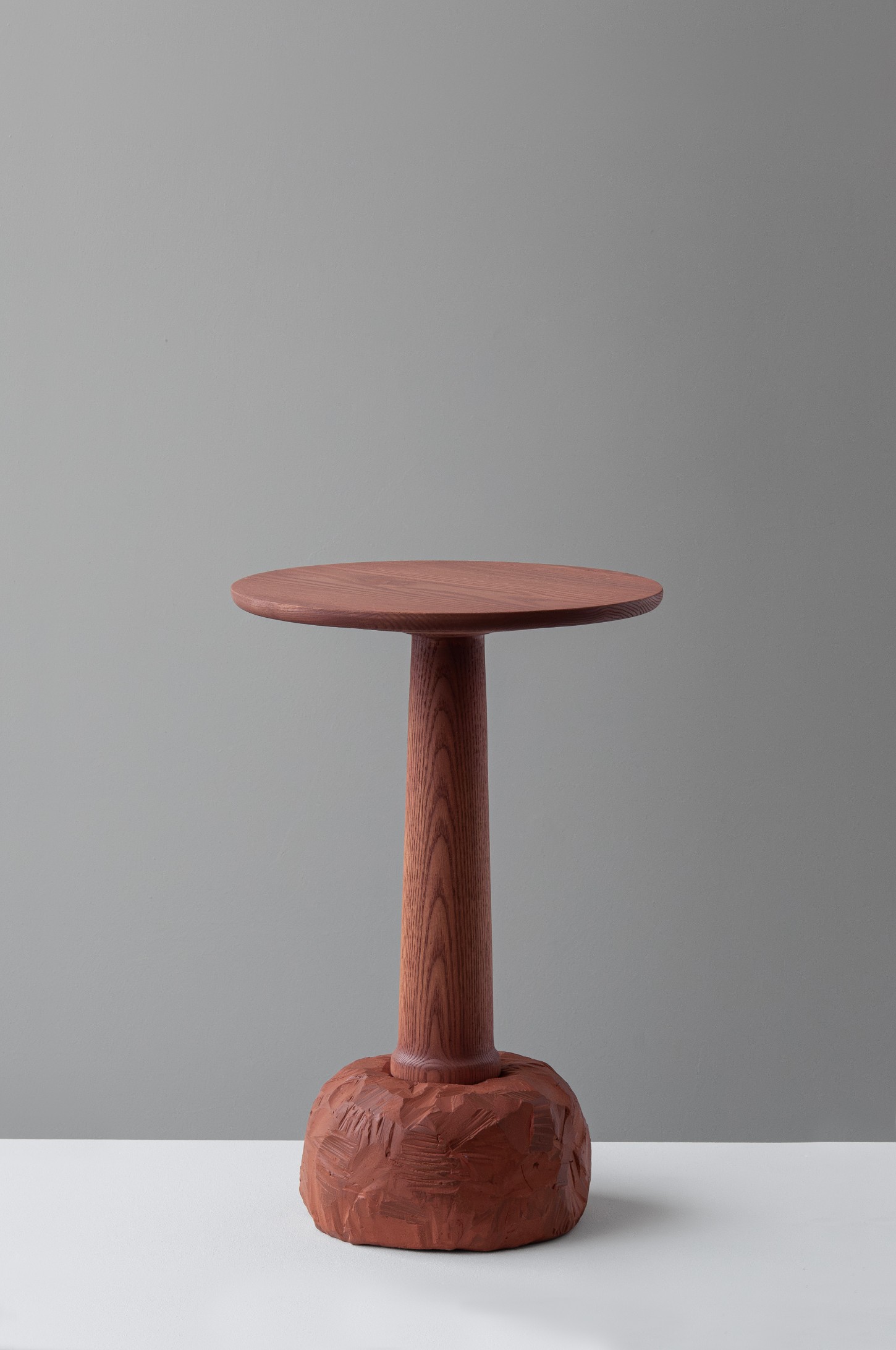 'Burn & Turn' by Adrian Bursell + Siri Svedborg — A pedestal table from 'Burn & Turn' featuring a turned timber column with vertical fluting, supporting a circular wooden top with visible grain.