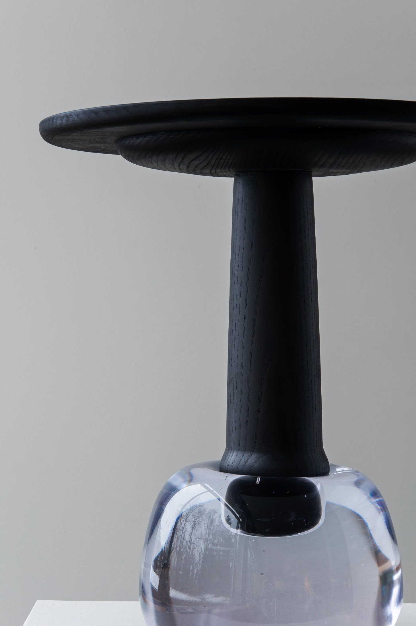 'Burn & Turn' by Adrian Bursell + Siri Svedborg — A pedestal table featuring a turned timber column with pronounced vertical fluting, supporting a circular timber top with visible wood grain.