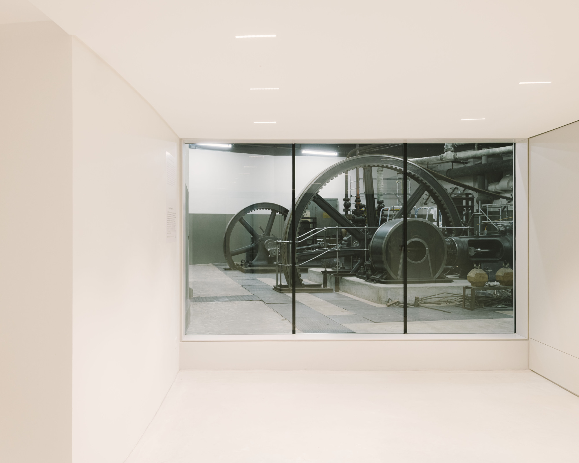 Paris' La Bourse de Commerce redesigned by Tadao Ando — A three-panel glazed threshold frames the industrial machinery of La Bourse de Commerce's exterior courtyard.