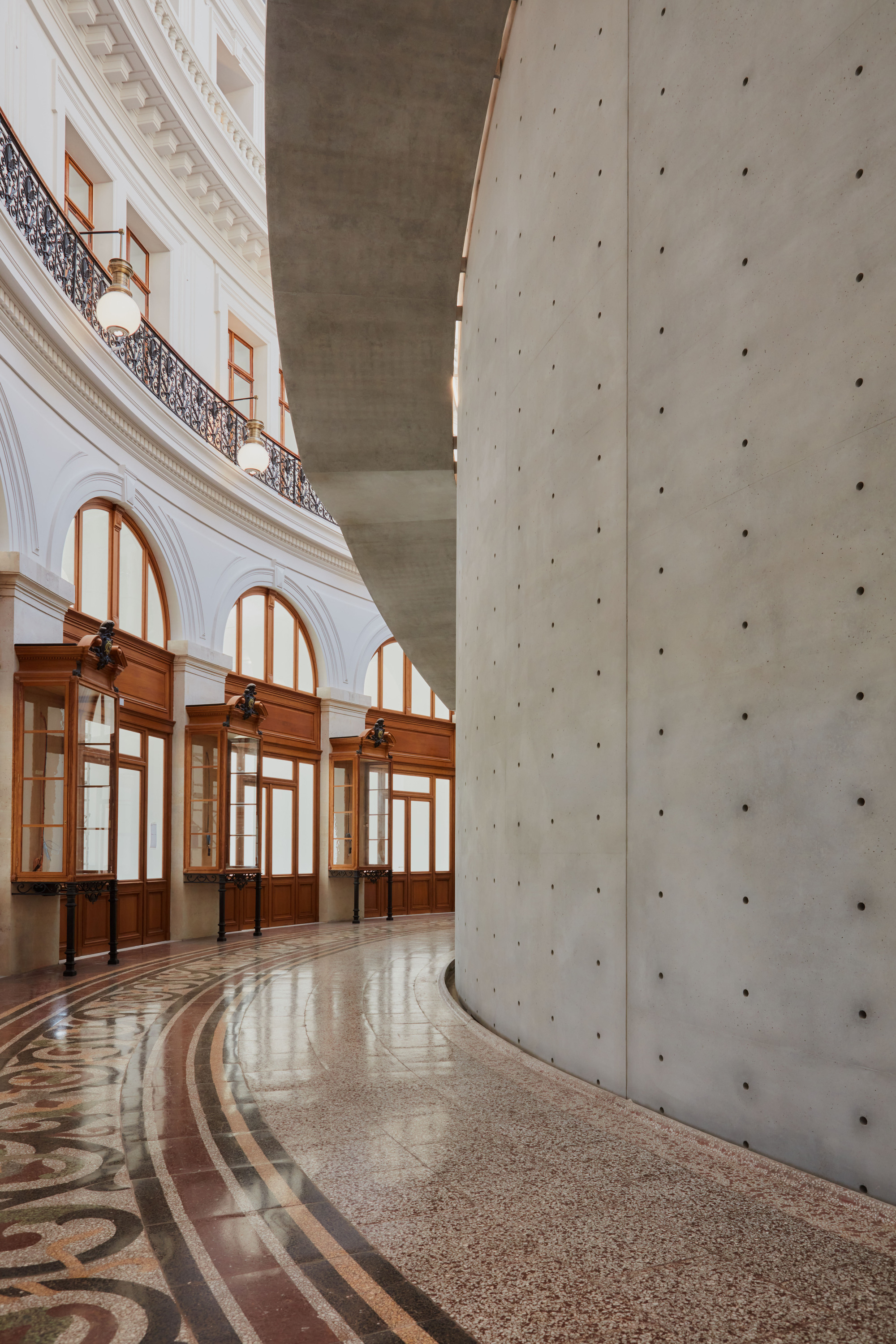 Paris' La Bourse de Commerce redesigned by Tadao Ando — A monolithic concrete cylinder, perforated with regularly-spaced dark holes, rises through the rotunda of La Bourse de Commerce.