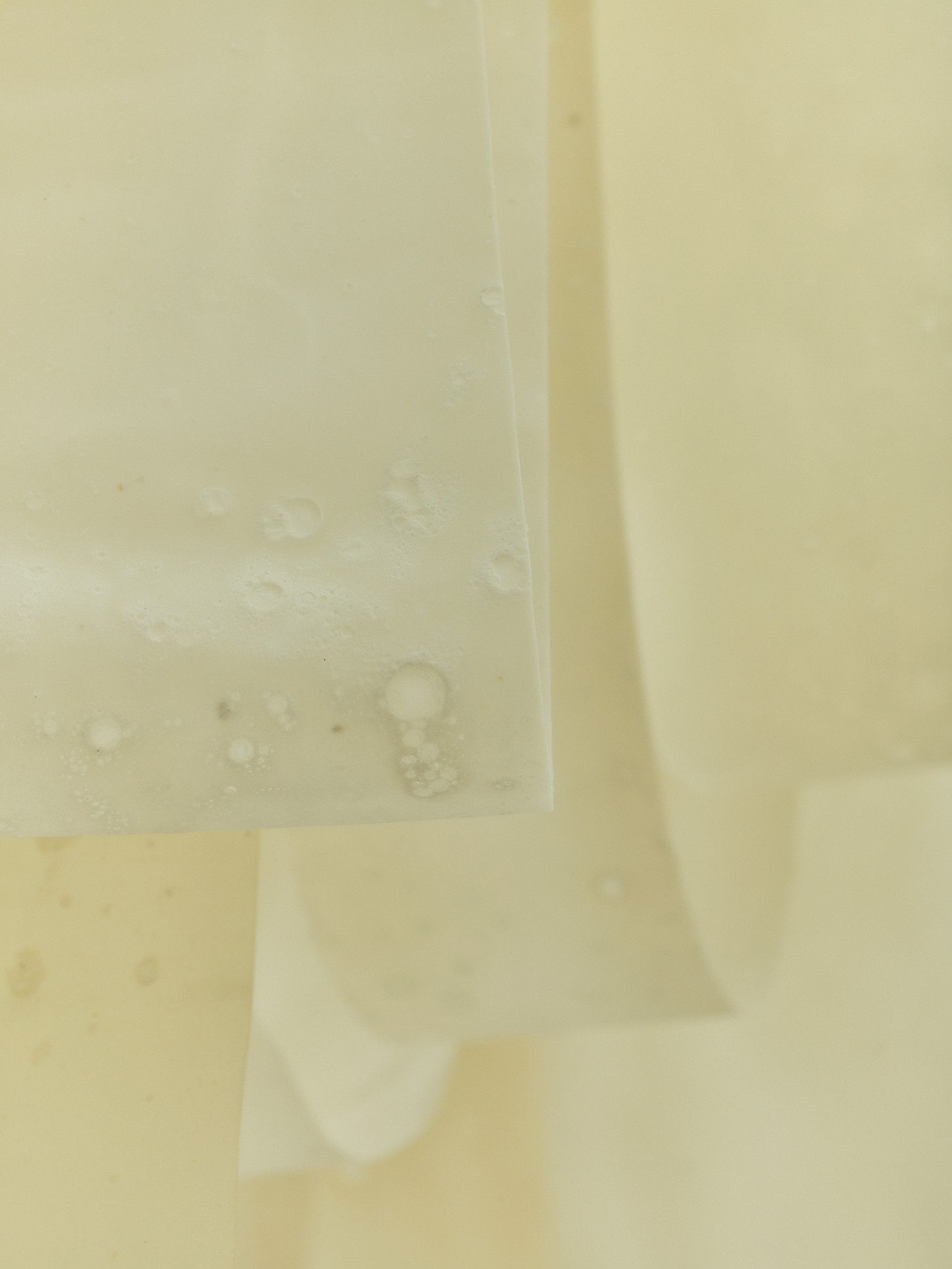 'White Utopia' by Natural Material Studio — A close-up detail of the bioplastic bathroom installation reveals the seamless construction of a cream-colored basin integrated into curved alcove walls.