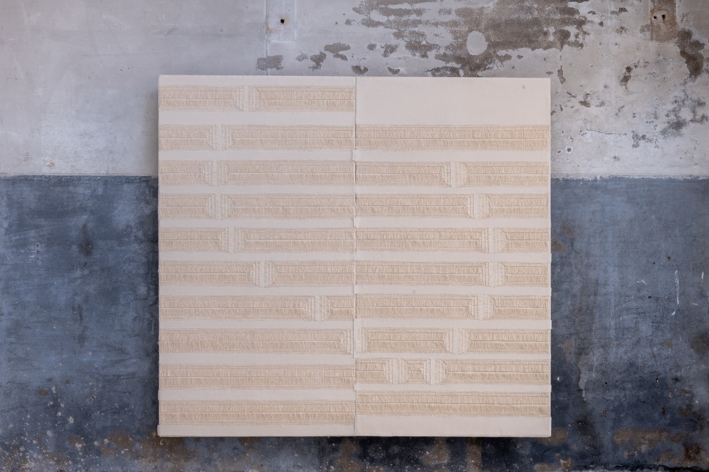 'Repetition is a Form of Change' by Sophie Rowley at Looiersgracht 60 — A modular grid installation composed of approximately 120 small rectangular linen or canvas units arranged in 12 horizontal rows.