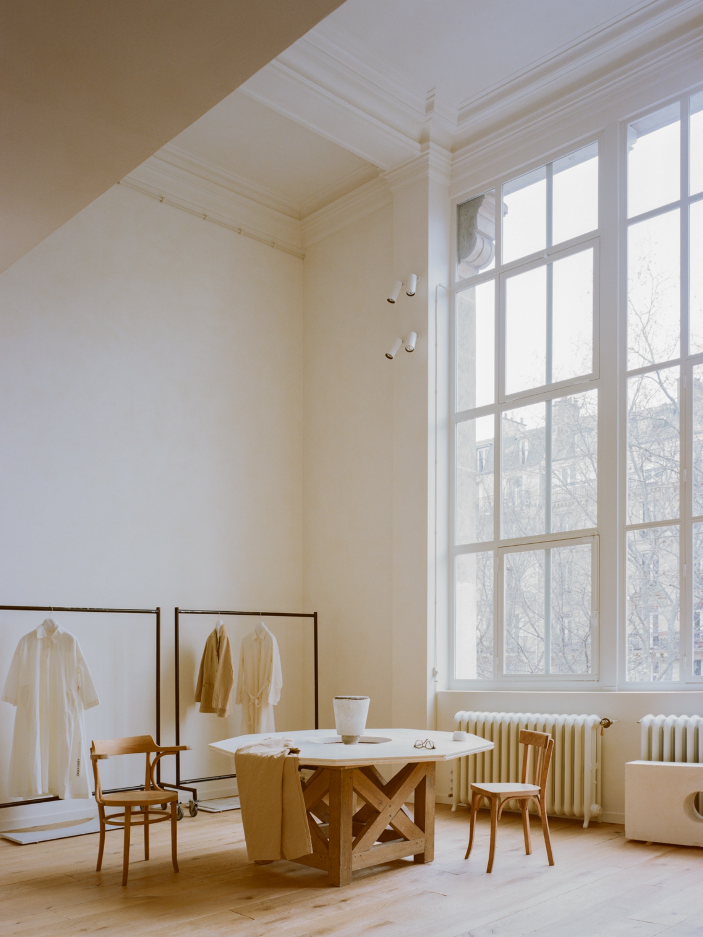 Casey Casey Showroom by Atelier NEA — The Casey Casey showroom occupies a light-filled upper floor with a 16-pane steel-framed window wall overlooking bare Parisian trees.
