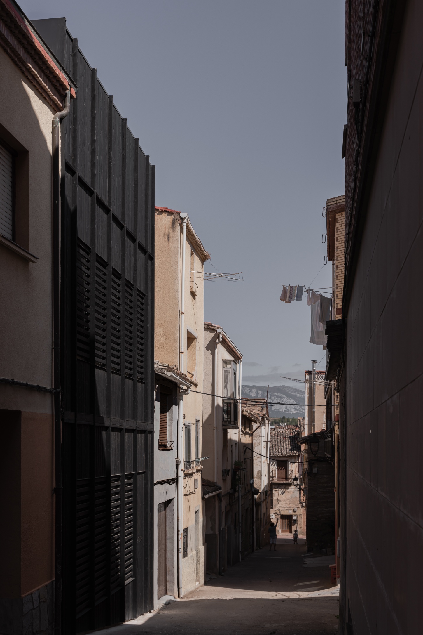 Tritium Winery by Francesc Rifé Studio — A narrow alley in Cenicero's historic core frames the winery's contemporary intervention at street level.