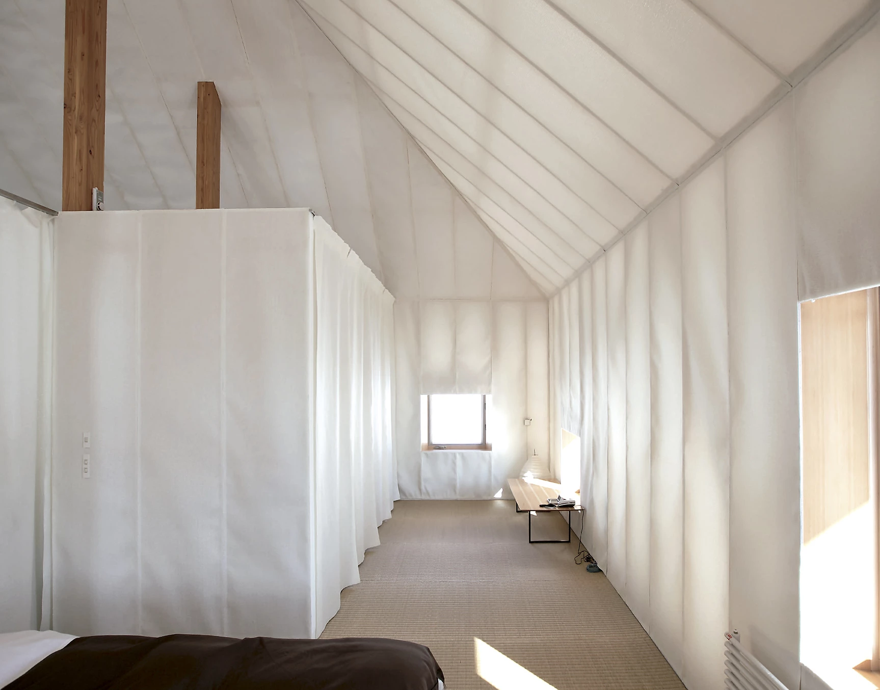 Mêmu Meadows Earth Hotel by Kengo Kuma — Interior passage of the Mêmu Meadows prototype revealing the post-and-beam structural system.