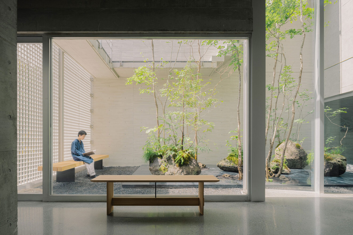 Arc’teryx Tokyo Creation Center by Torafu Architects — A framed courtyard view through expansive glazing reveals the Arc'teryx Creation Center's integration of interior and exterior.