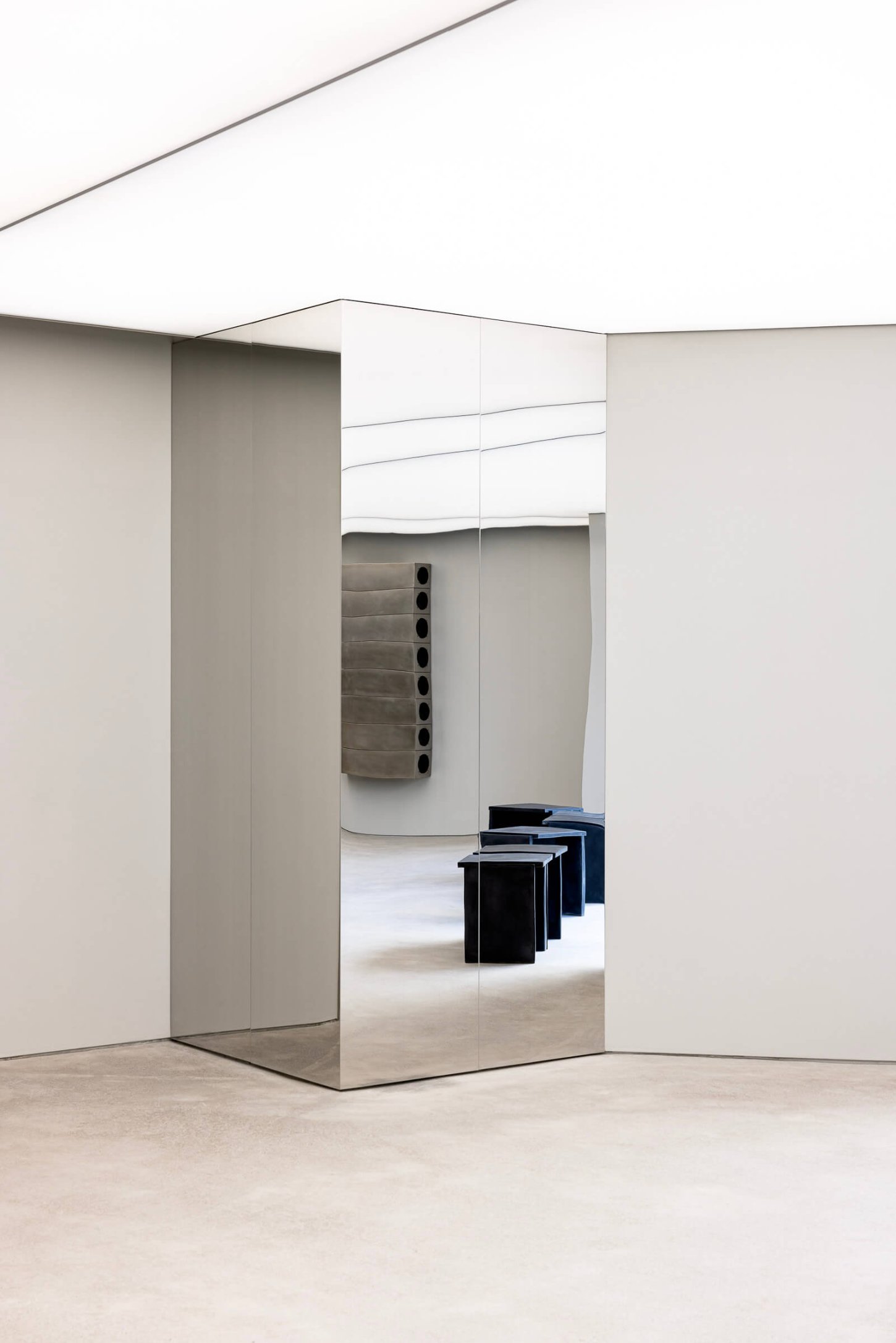 Mardi Mercredi store by Creative Studio Unravel — A mirrored structural column serves as a threshold within the Mardi Mercredi store, its polished surface reflecting the gallery-like space beyond.