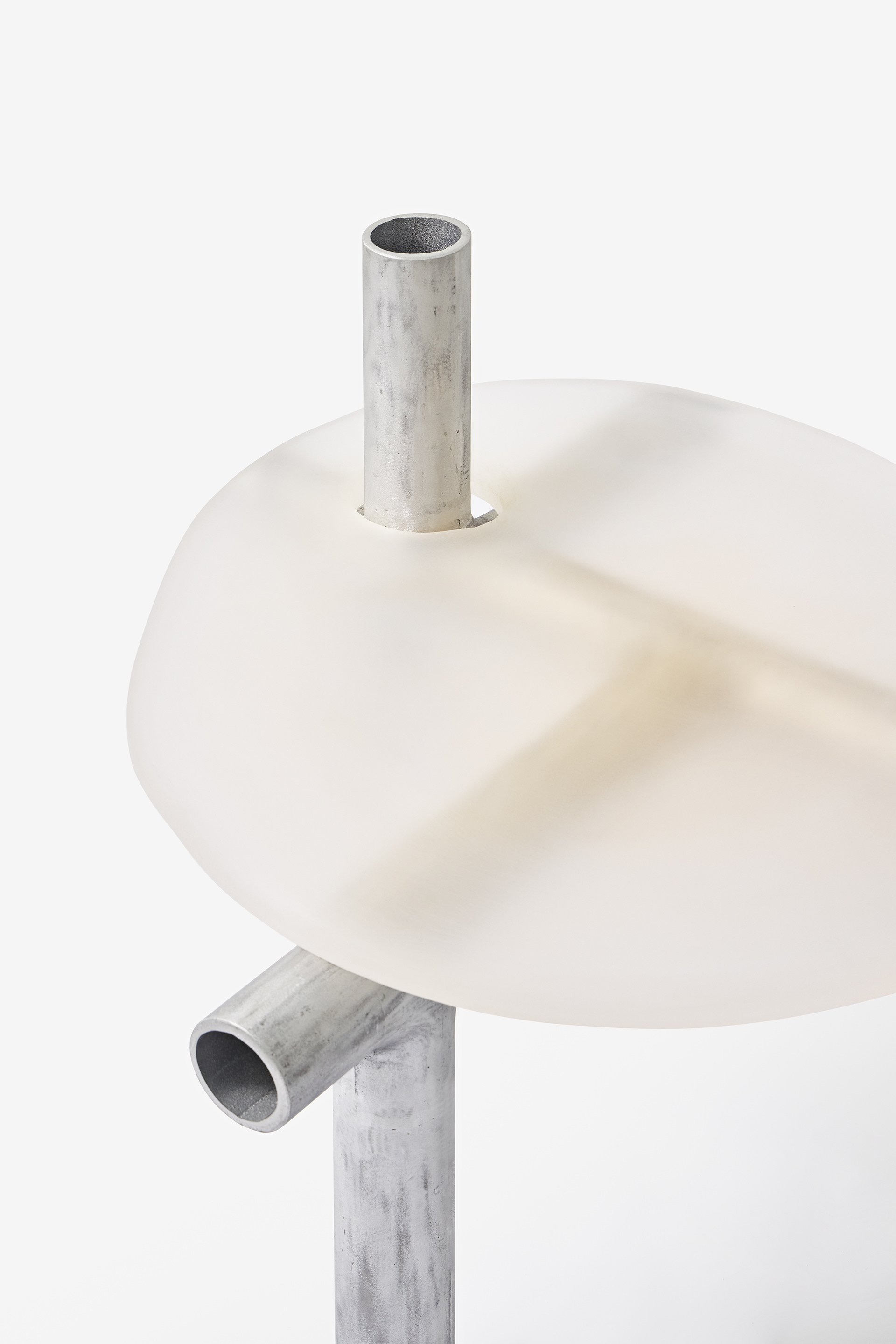 Cylinder Series by Jeonghwa Seo — A cantilevered table from the Cylinder Series presents a frosted white acrylic circular top mounted on a tripod aluminum frame.