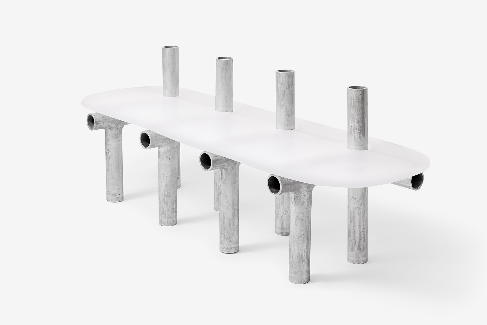 Cylinder Series by Jeonghwa Seo — A sculptural table from Seo's Cylinder Series features a frosted white acrylic circular top supported by a framework of weathered grey-silver aluminum tubes.
