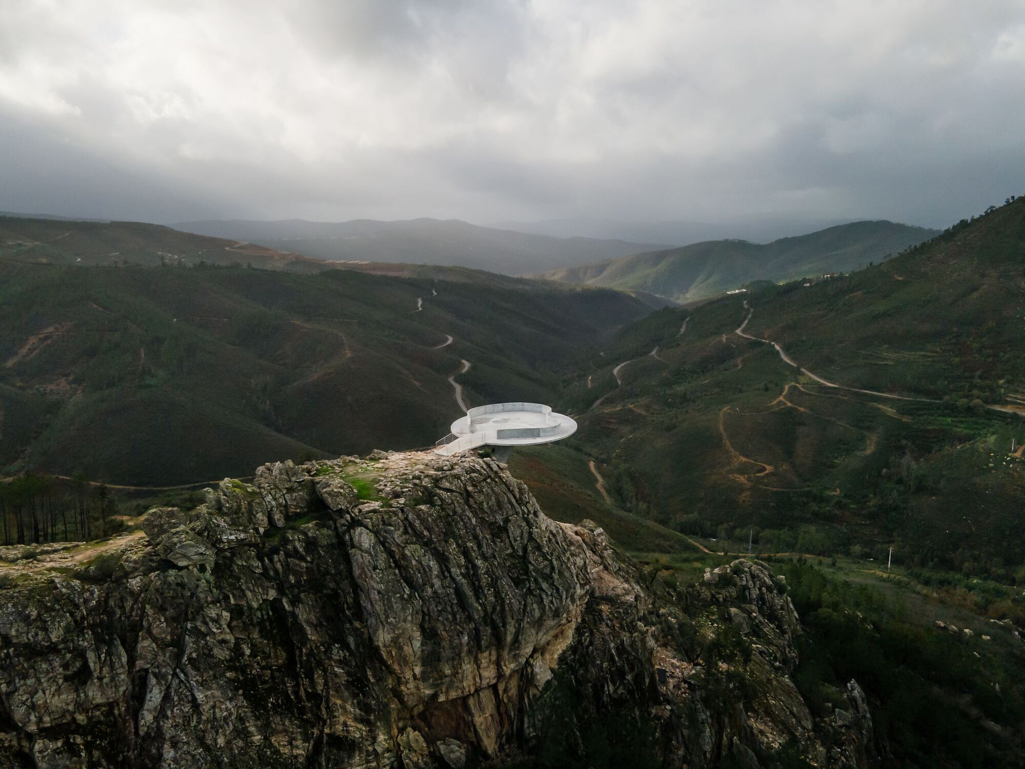 Renovation of the Zebro Viewpoint by Álvaro Siza Vieira by Alvaro Siza — Álvaro Siza Vieira's circular concrete platform sits elevated on the rocky outcrop overlooking the Douro Valley, its white reinforced concrete form...