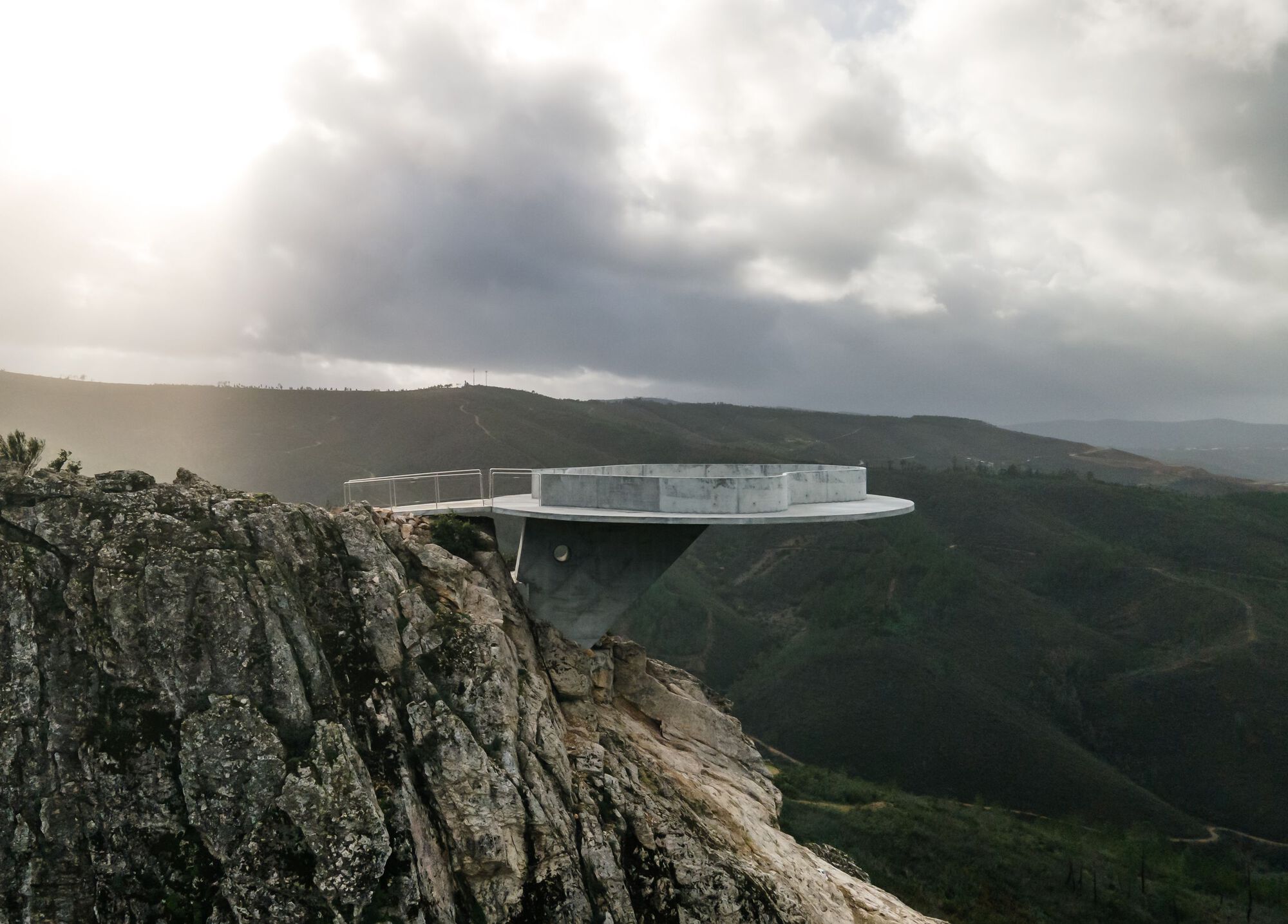 Renovation of the Zebro Viewpoint by Álvaro Siza Vieira by Alvaro Siza — Álvaro Siza Vieira's circular concrete platform cantilevers dramatically from the rocky massif at Zebro Viewpoint, its white reinforced concrete form...
