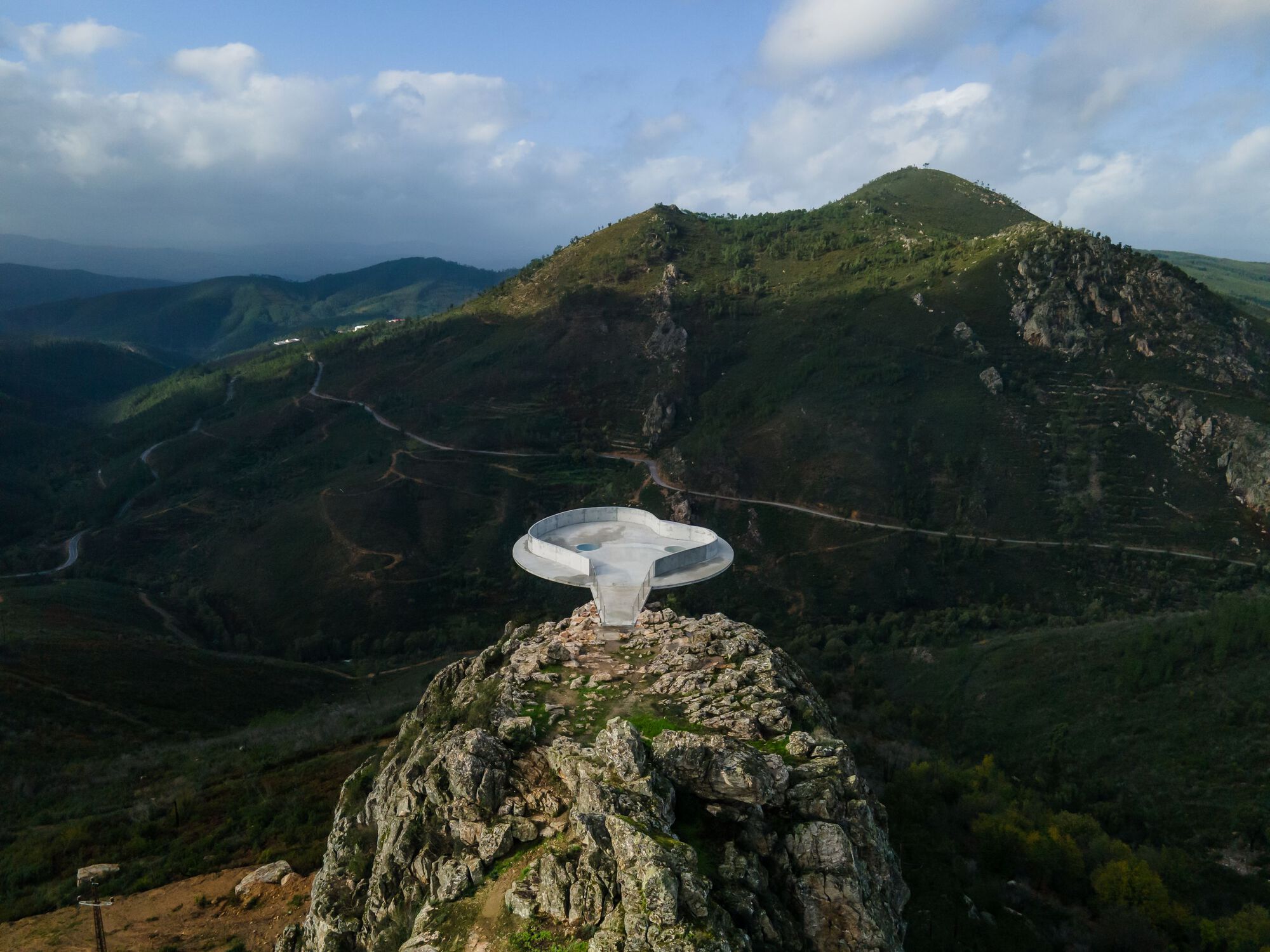 Renovation of the Zebro Viewpoint by Álvaro Siza Vieira by Alvaro Siza — Álvaro Siza Vieira's Zebro Viewpoint renovation presents a white reinforced concrete circular platform cantilevered from a rocky stone outcrop, capturing...