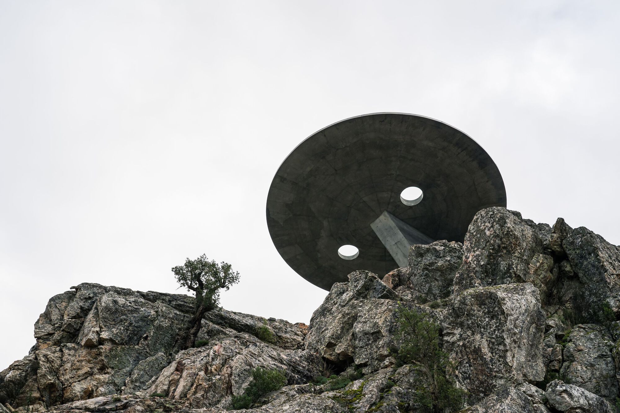 Renovation of the Zebro Viewpoint by Álvaro Siza Vieira by Alvaro Siza — Siza Vieira's circular concrete platform appears suspended above the rocky granite massif, its white reinforced concrete form contrasting sharply against...
