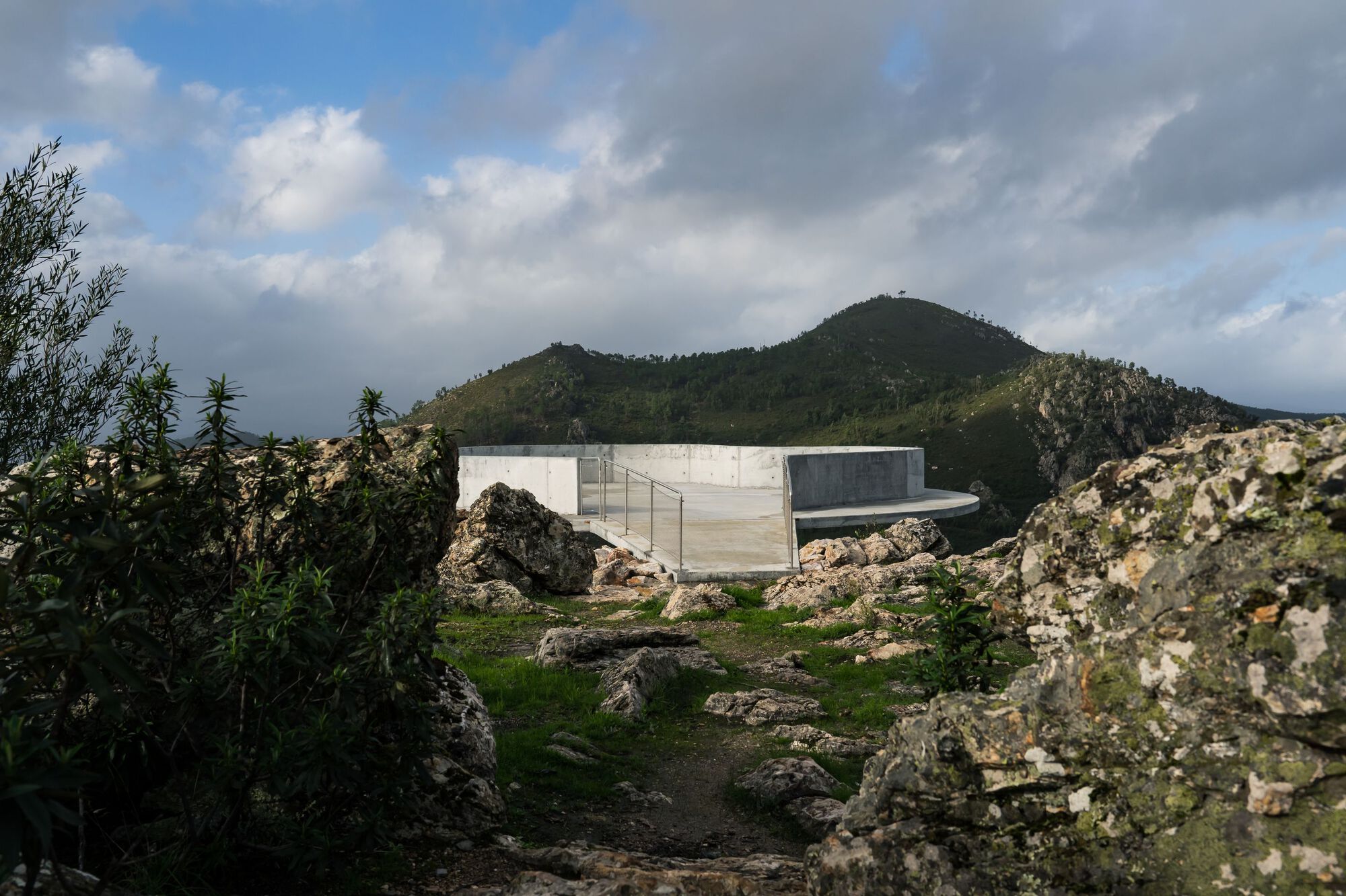 Renovation of the Zebro Viewpoint by Álvaro Siza Vieira by Alvaro Siza — Álvaro Siza Vieira's circular reinforced concrete platform emerges from a rocky hillside in Estreito, Portugal.