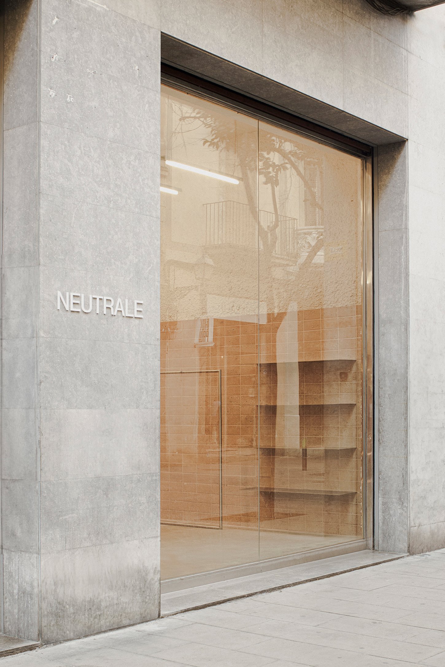 Neutrale by estudio DIIR — The storefront entrance of Neutrale presents a studied exercise in material restraint.