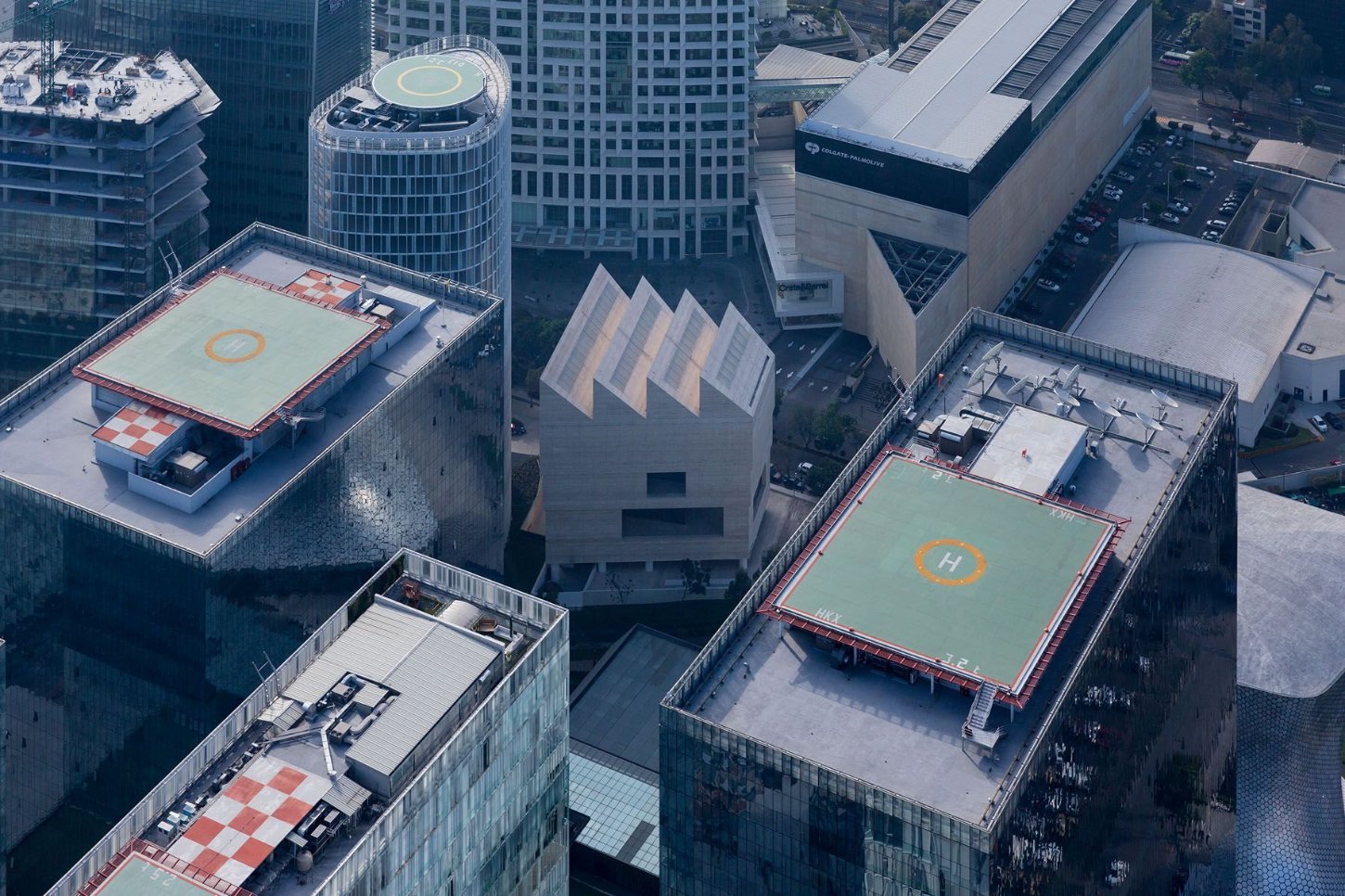 Museo Jumex by David Chipperfield Architects — Aerial view of Museo Jumex's rooftop landscape reveals the building's distinctive sawtooth silhouette composed of three angular peaks rendered in travertine...