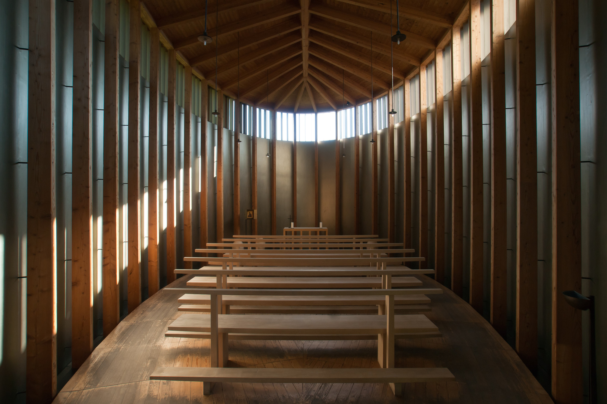 Saint Benedict Chapel by Peter Zumthor — Interior view of the chapel looking toward the altar, revealing Zumthor's spatial orchestration through light and material.