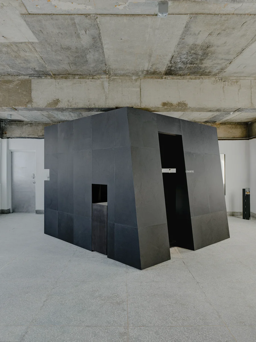 CONCRETED by molae, photographed by Noh Pu Reum — The Seoul showroom interior reveals a raw concrete ceiling with visible rebar and casting marks, paired with clinical white partition walls that create modular display zones.