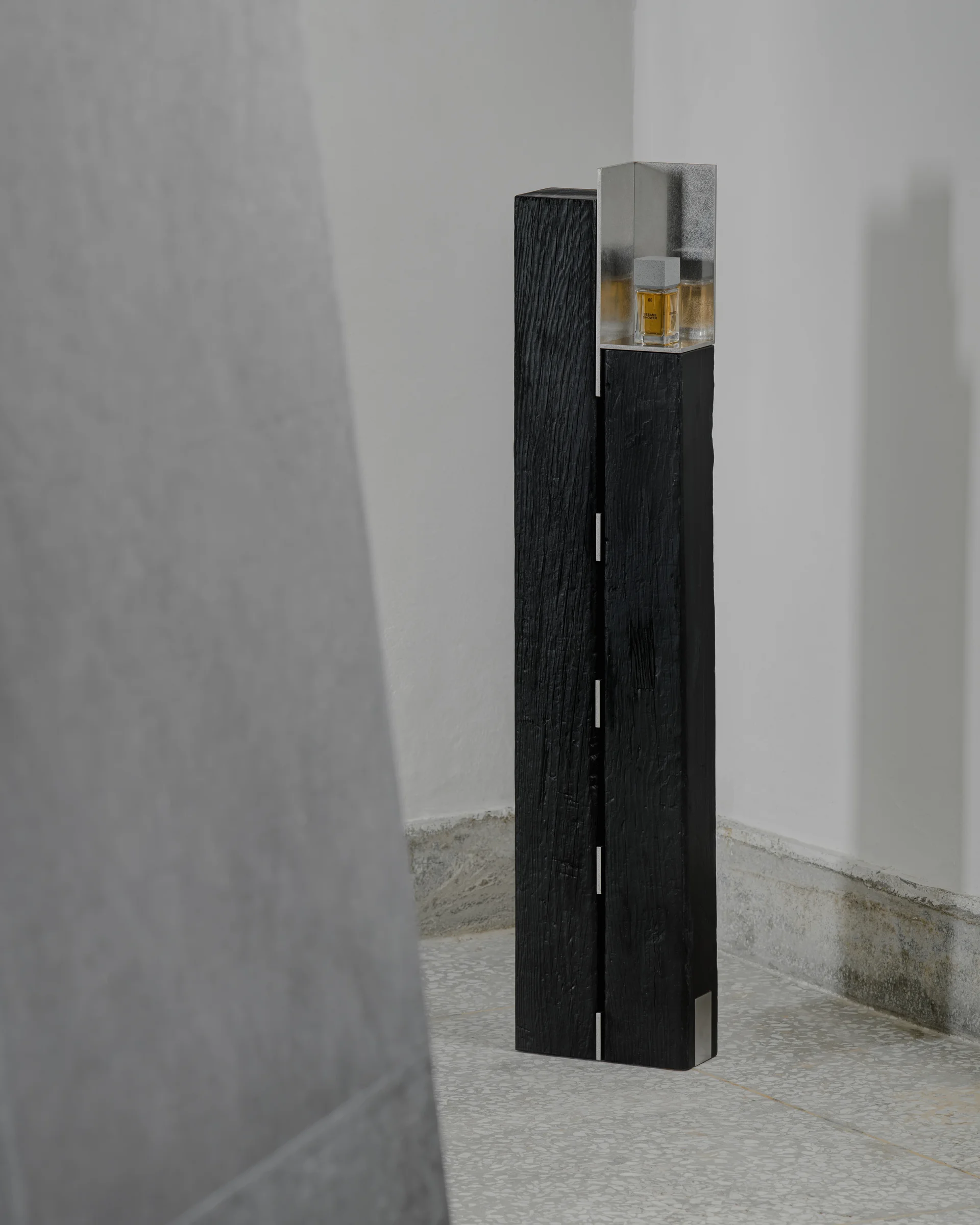 CONCRETED by molae, photographed by Noh Pu Reum — The entrance to CONCRETED's Seoul showroom is defined by a recessed threshold framed by charcoal-tiled walls.