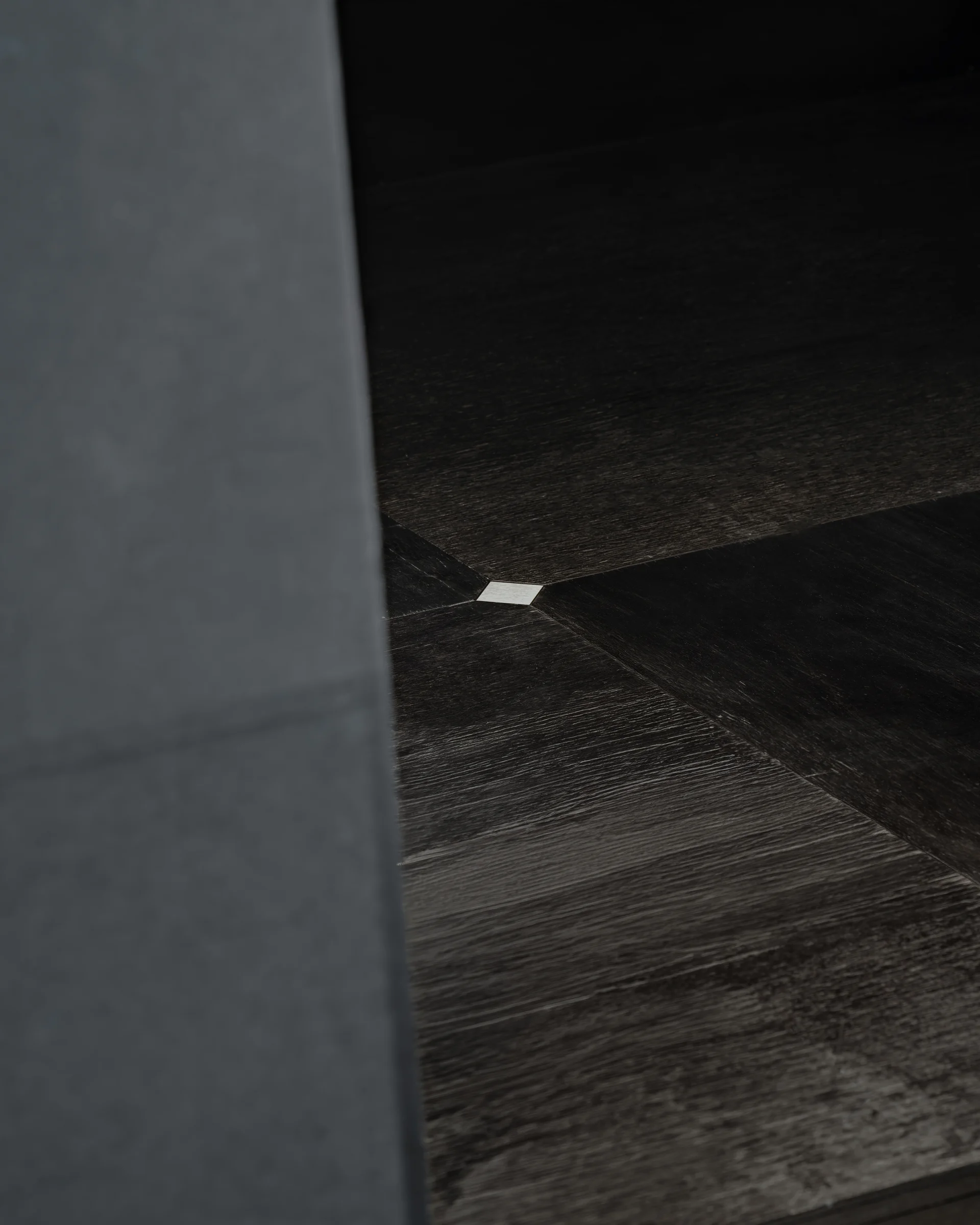 CONCRETED by molae, photographed by Noh Pu Reum — A horizontal corridor stretches into darkness, punctuated by eight illuminated rectangular openings that reveal white interior spaces.