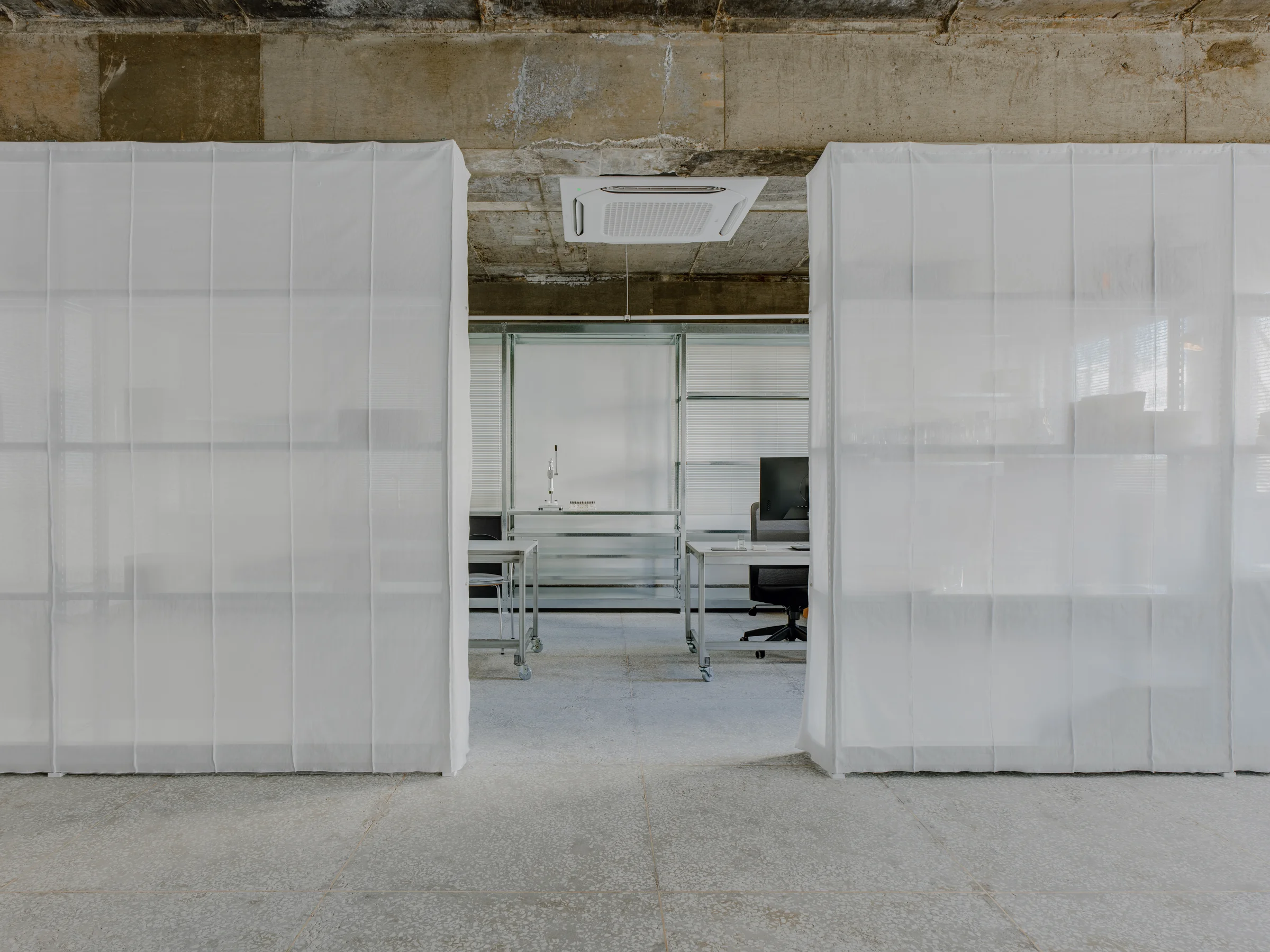 CONCRETED by molae, photographed by Noh Pu Reum — The showroom's workspace features a mobile table with aluminum frame and white laminate top, fitted with casters for flexibility.