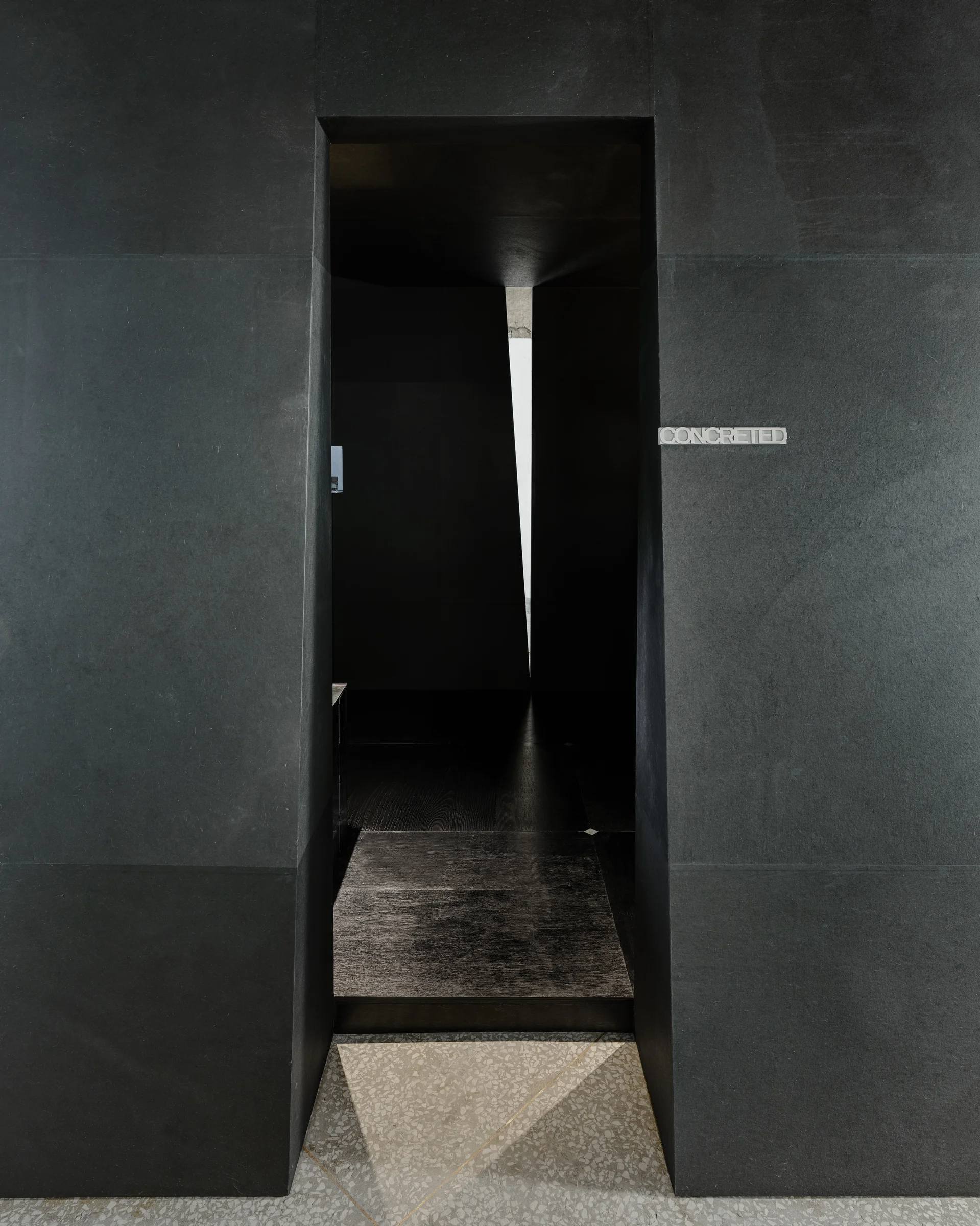 CONCRETED by molae, photographed by Noh Pu Reum — A close-up detail of the CONCRETED Seoul showroom reveals the material and branding strategy through layered vertical surfaces.